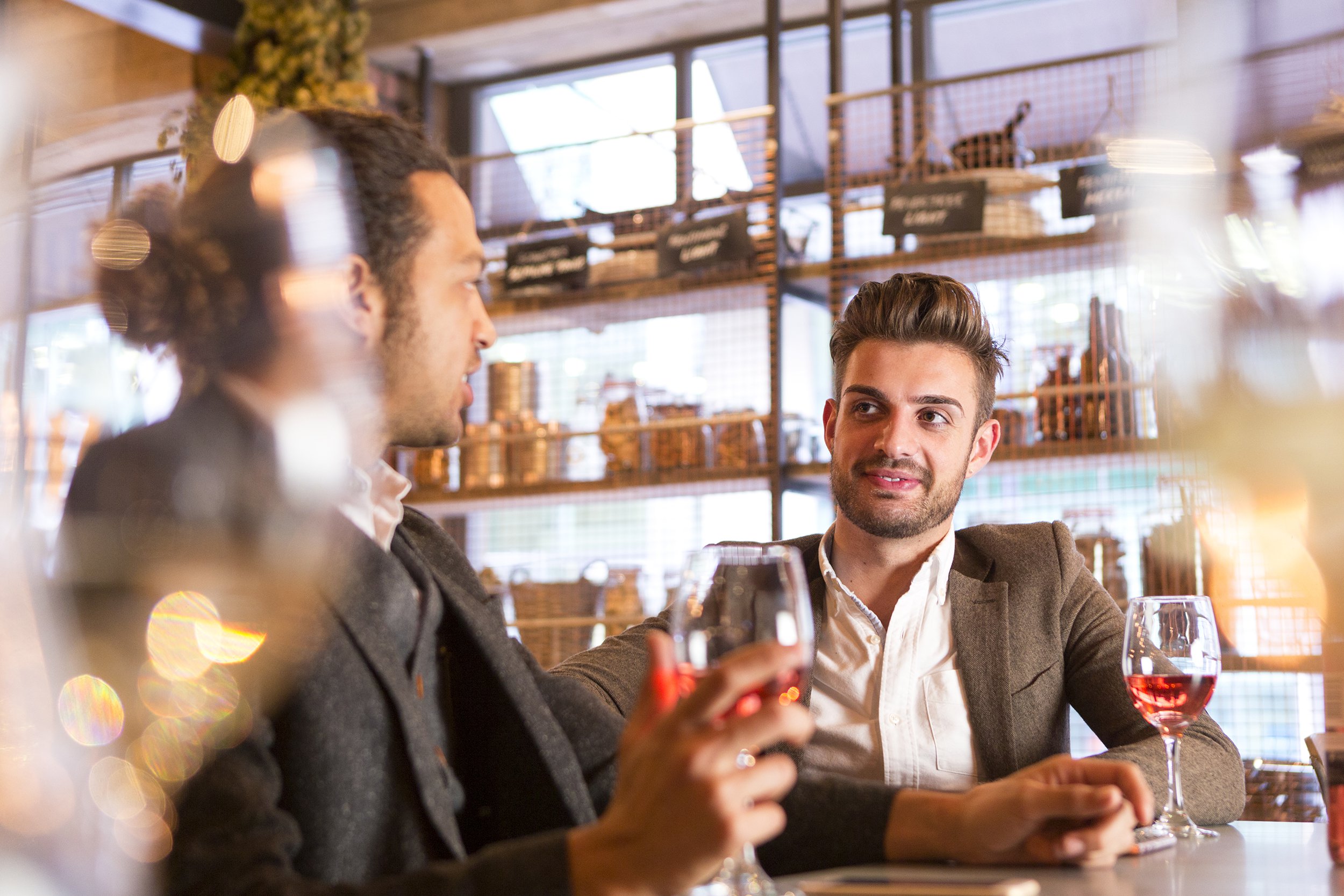 gay couple having wine at bar