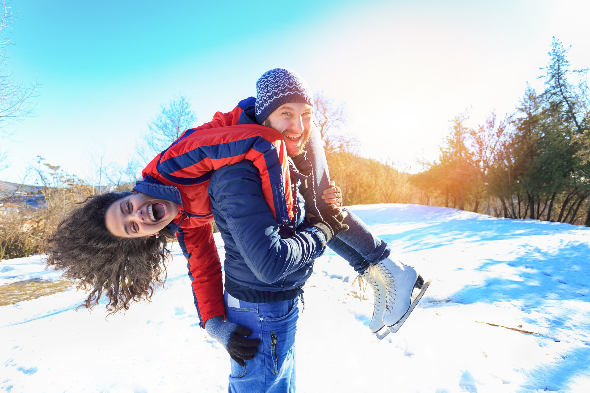 man carrying on shoulder his girlfriend in the snow
