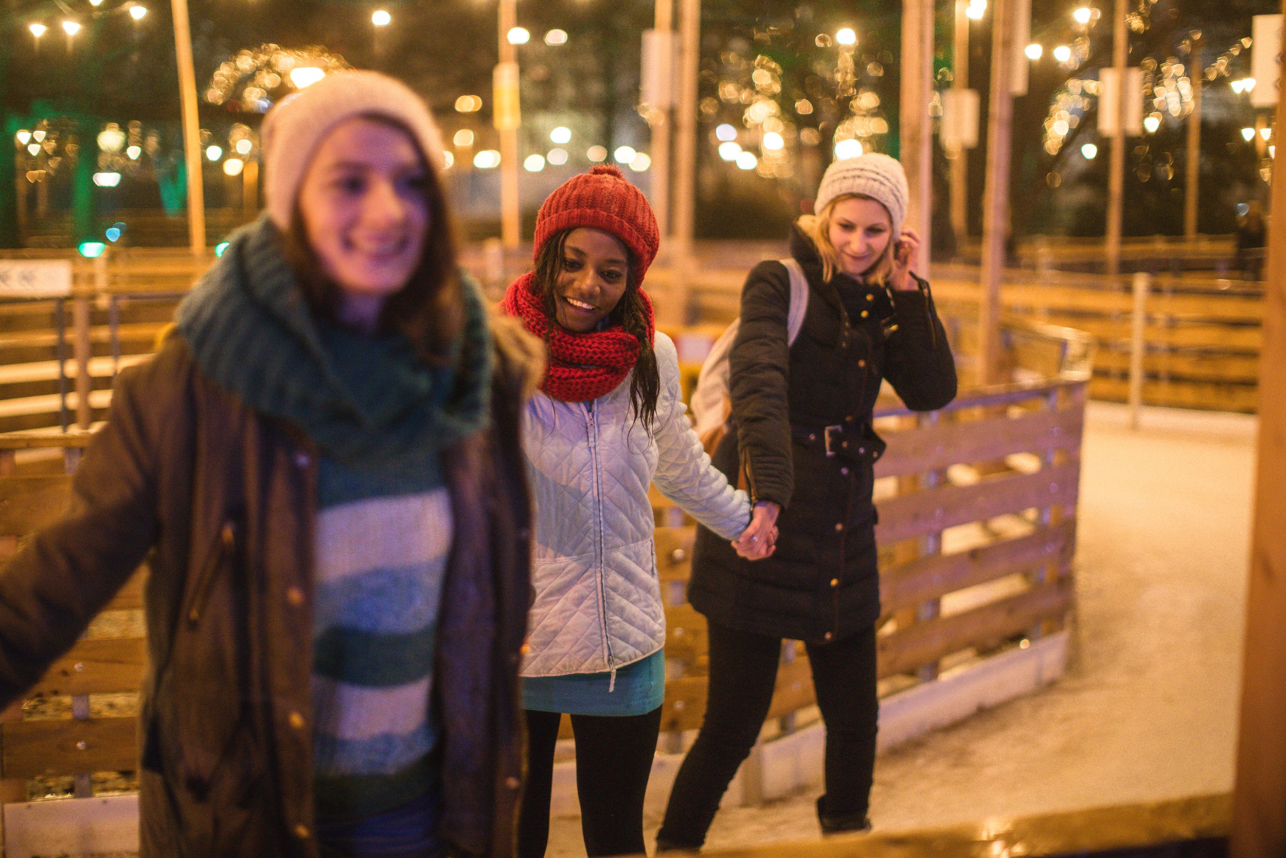 girlfriends ice skating while holding hands