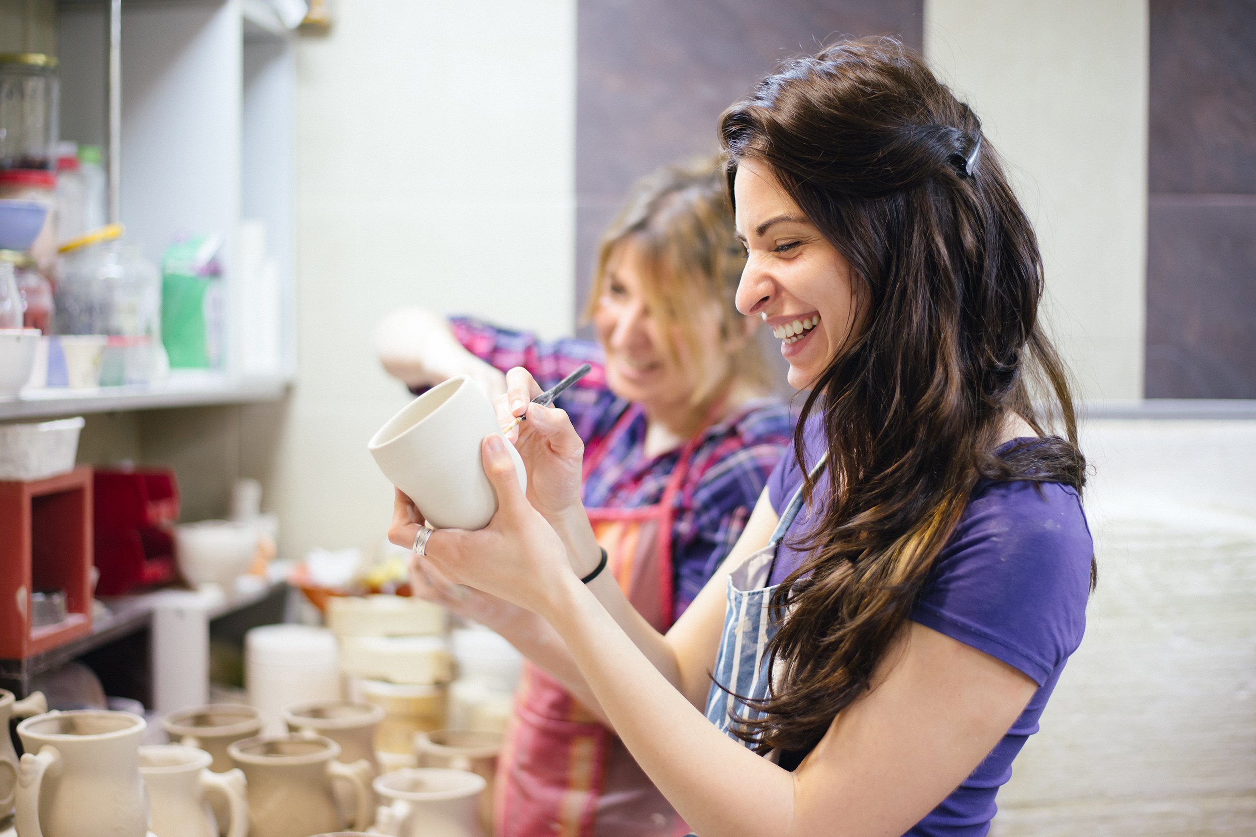 two women painting pottery
