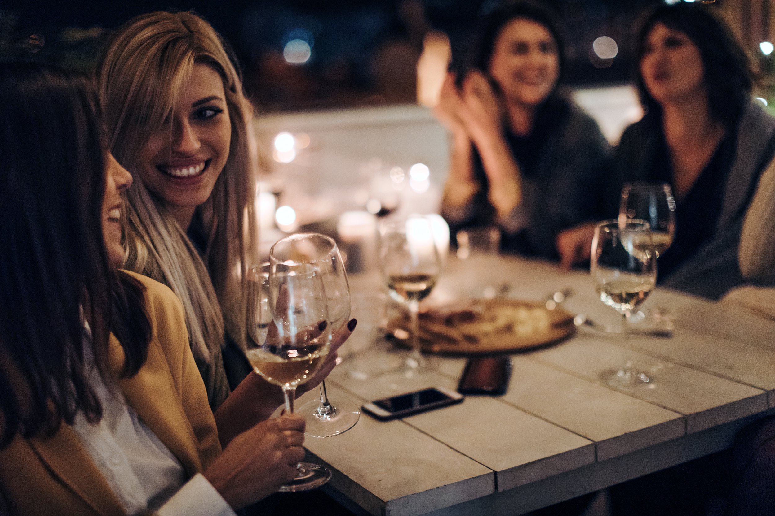 women drinking wine while out