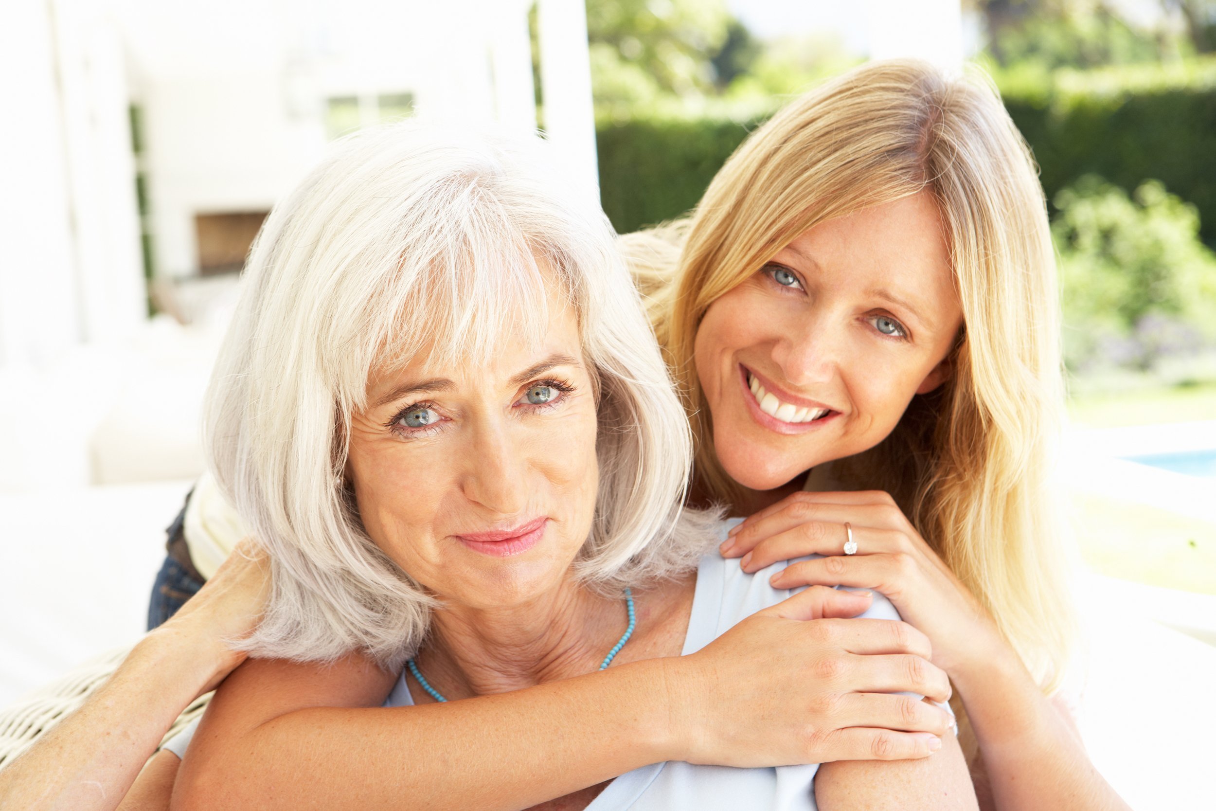 mother and adult daughter relaxing on sofa