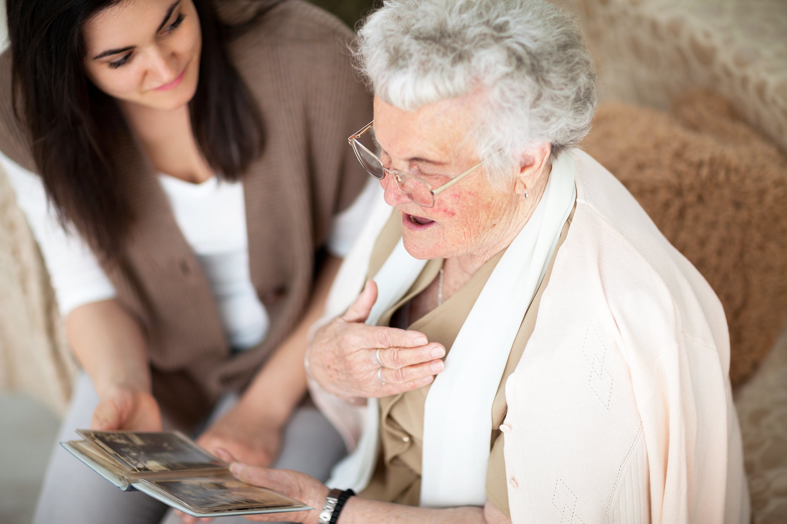 grandma showing old photo album to her granddaughter