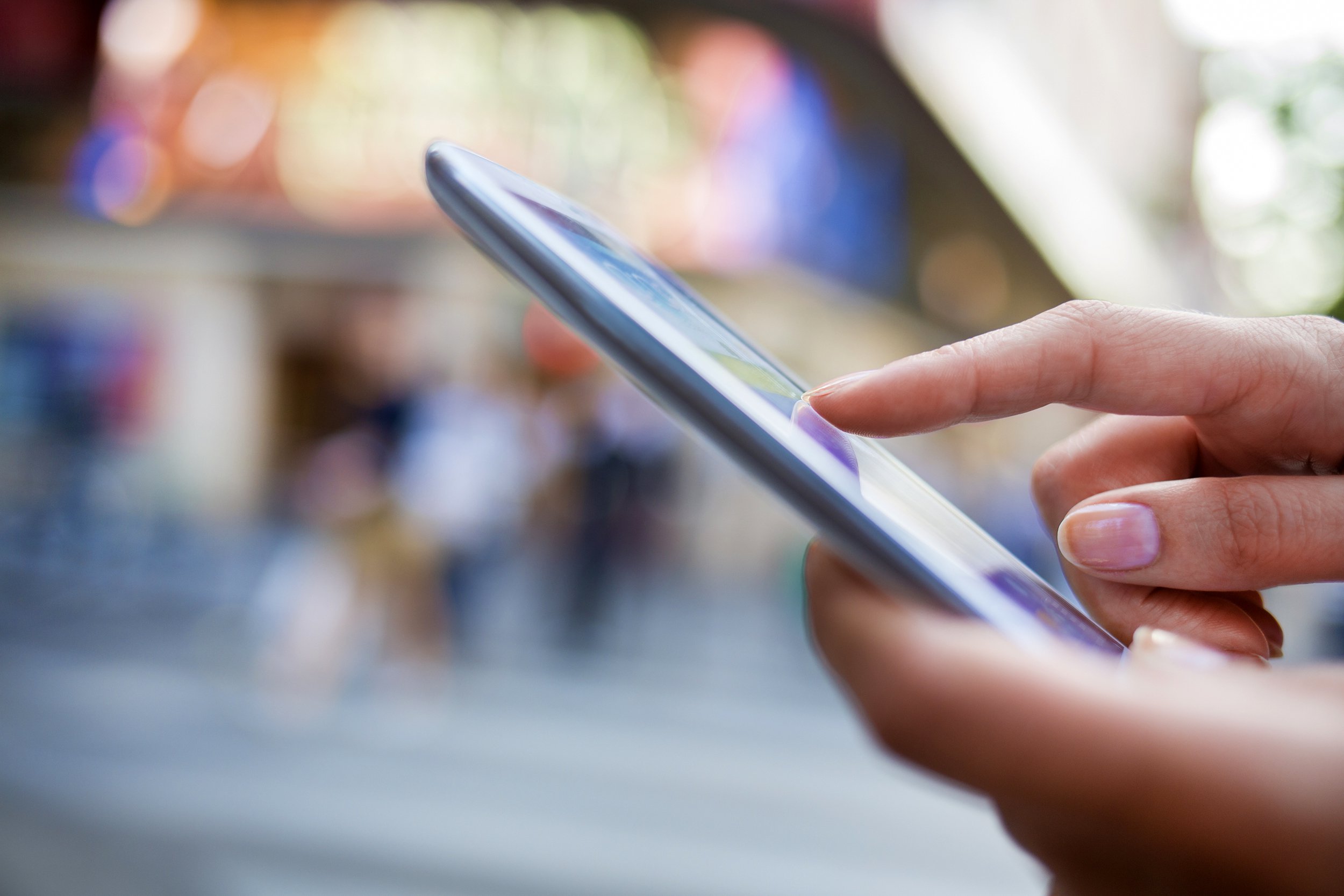 Closeup of person looking at smartphone in front of blurred theater