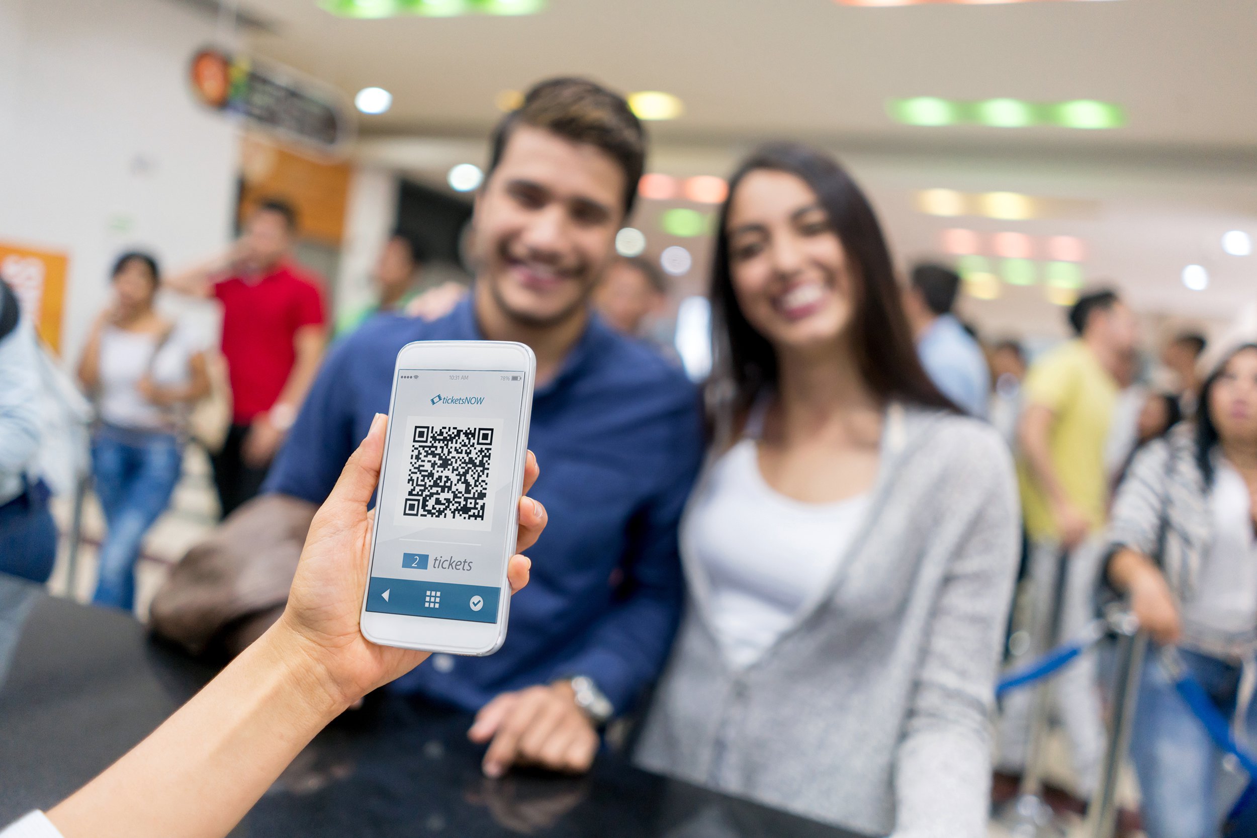 Couple showing eticket on phone at movie theater counter