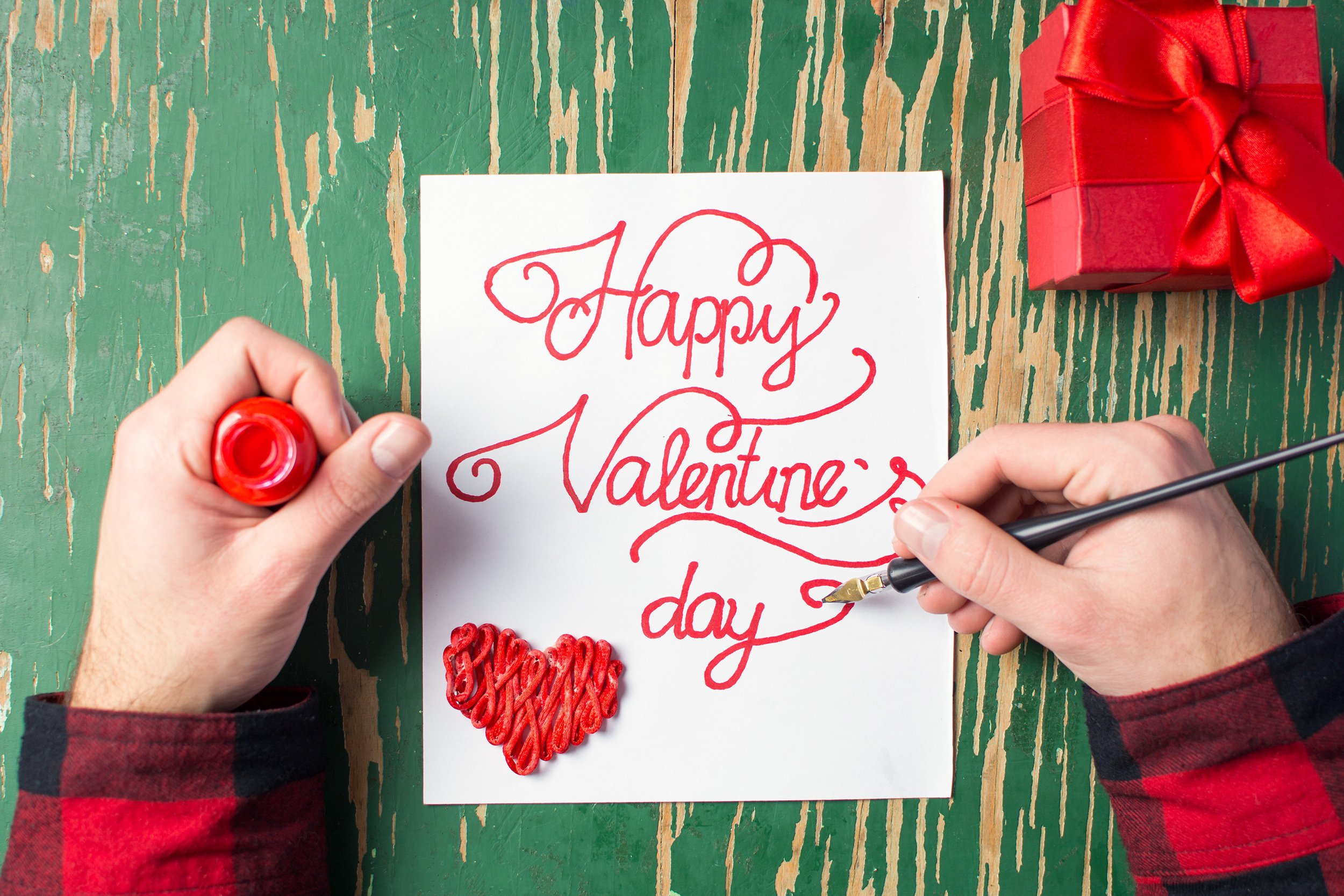 Hands creating a homemade Valentine's Day card