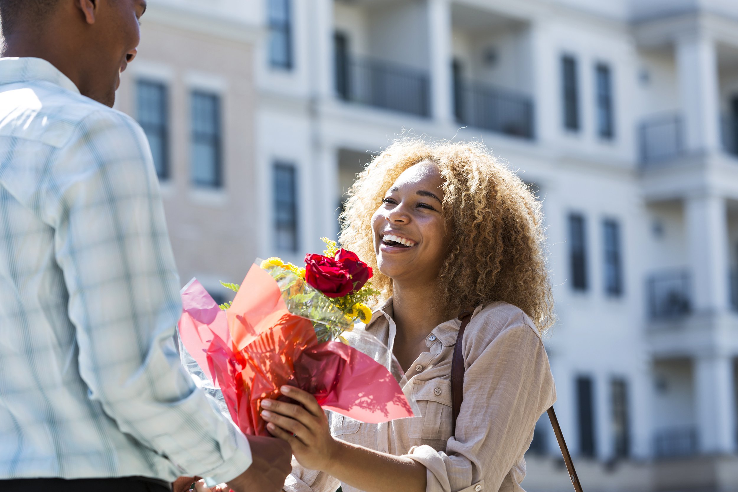 Man giving bouquet of flowers to woman