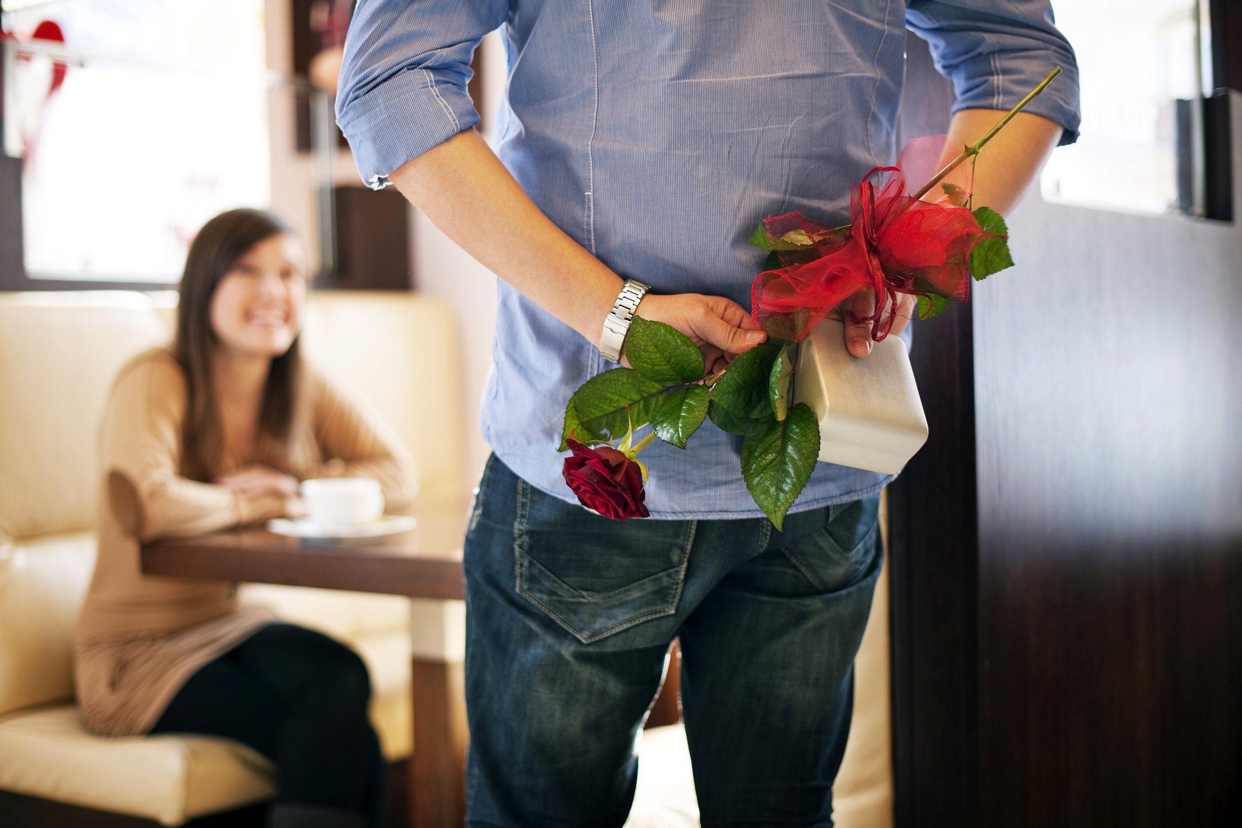 Man holding single rose behind his back