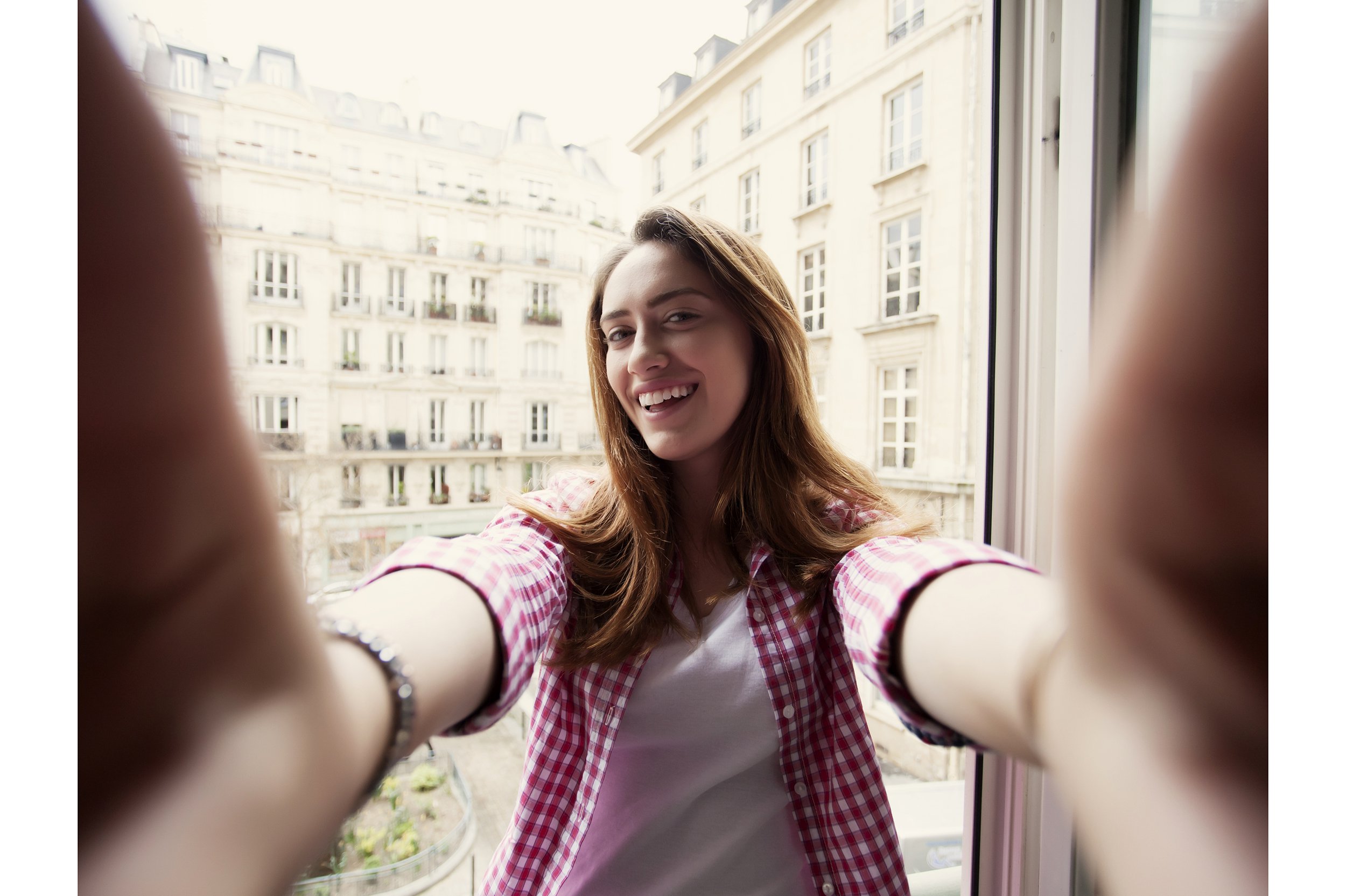 Woman taking selfie in front of window