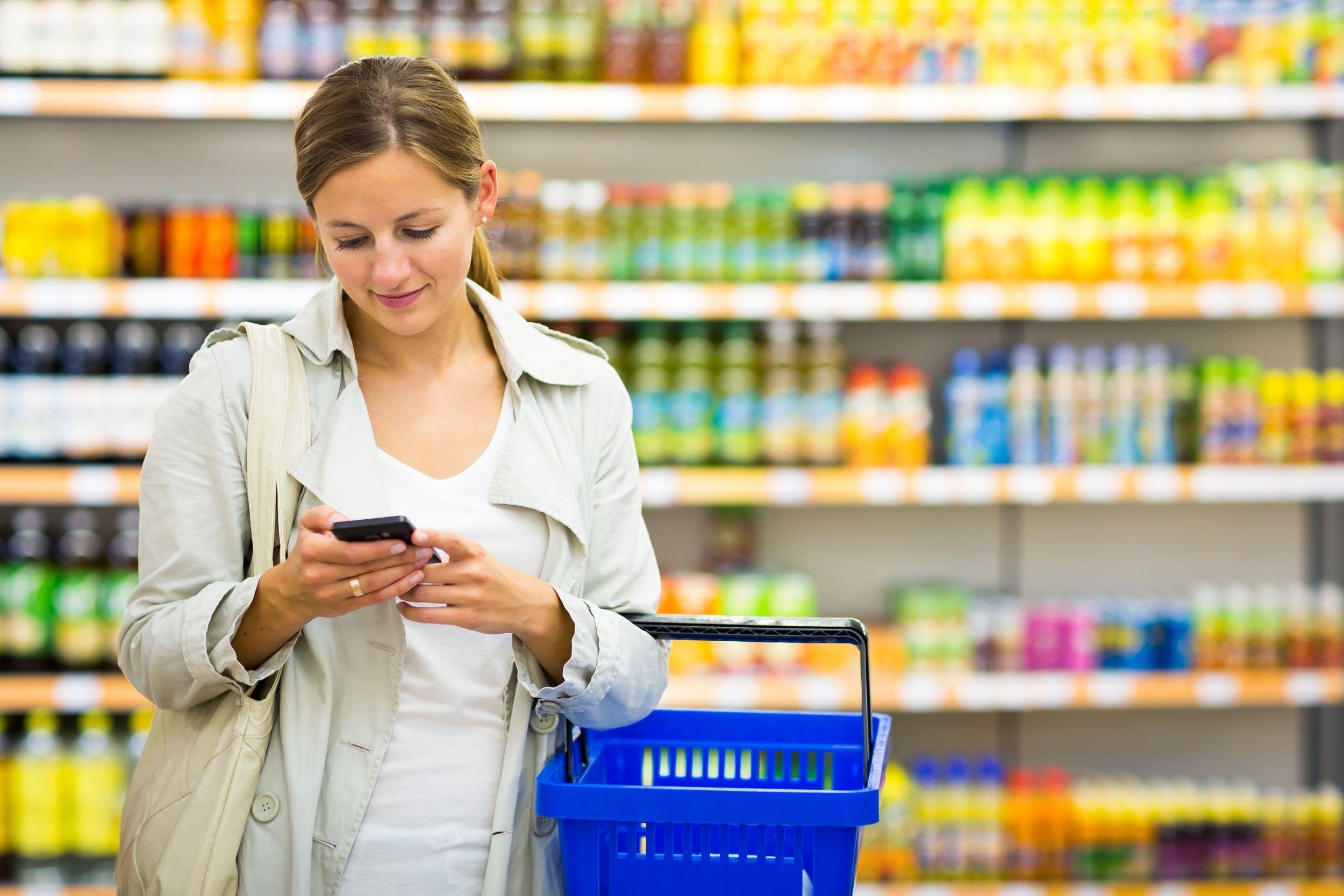 woman checking phone while in drugstore