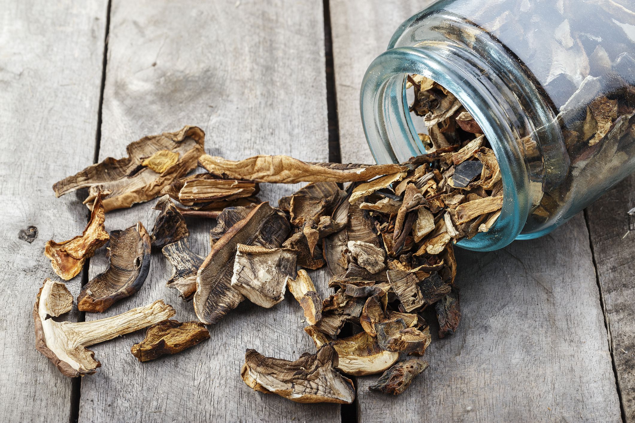 Dried mushrooms in a jar, sliced dried boletus on a wooden background