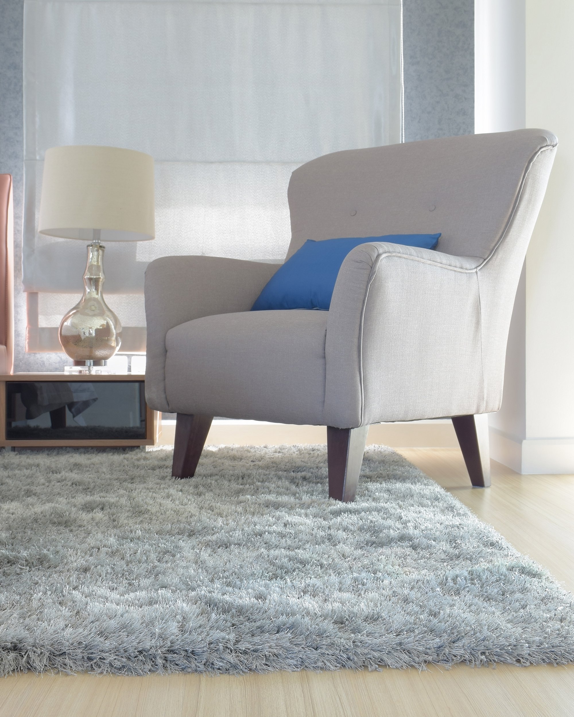 gray upholstery armchair with blue pillow in modern interior living room