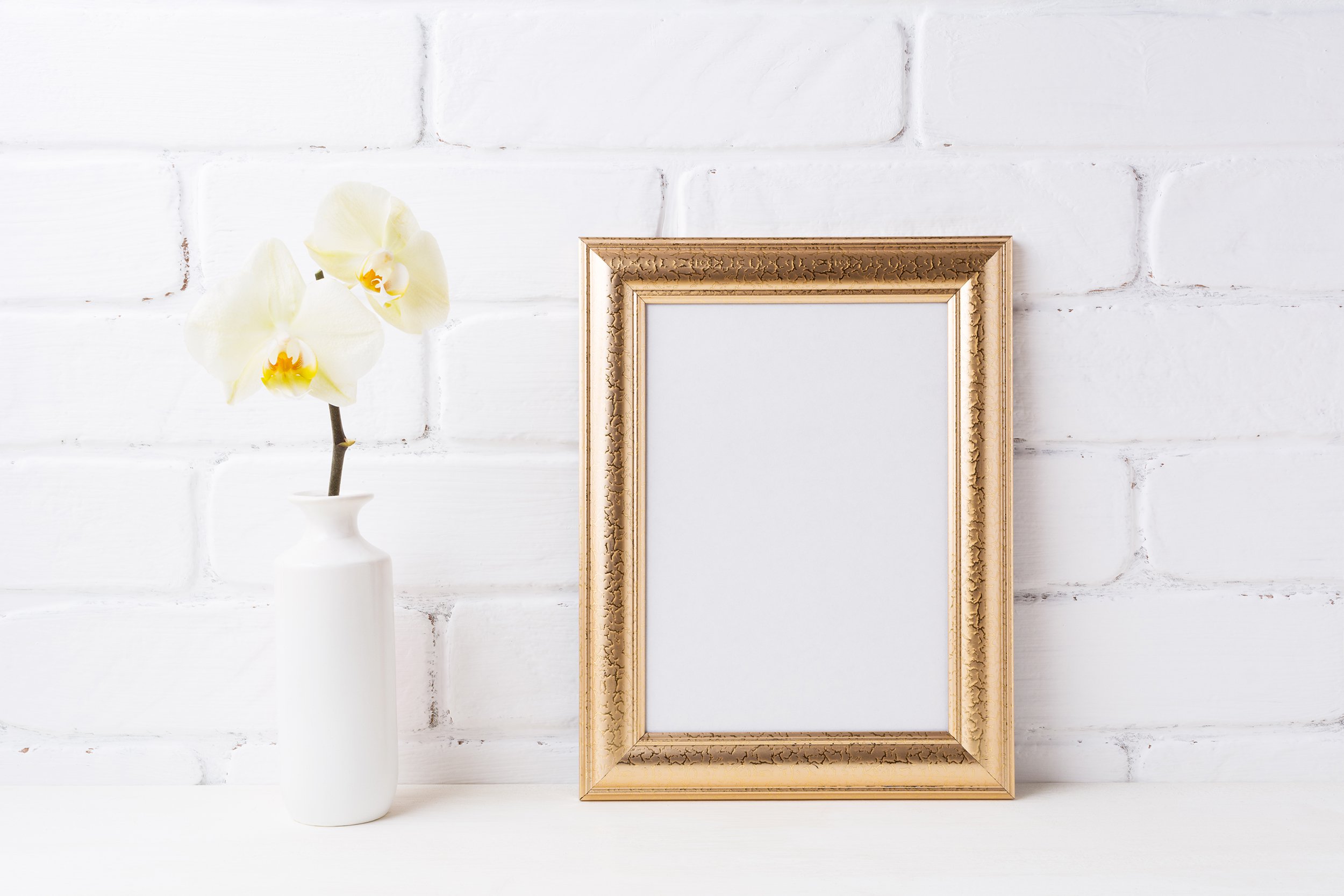 gold photo frame with soft yellow orchid in vase