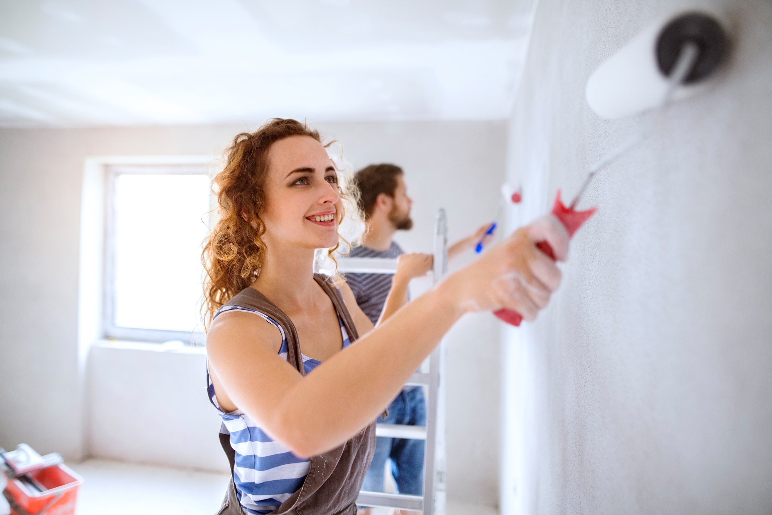 young couple painting walls in their new house