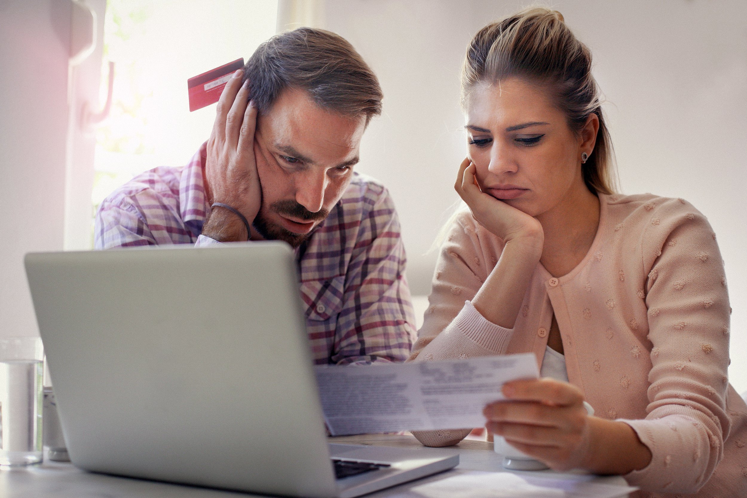 Couple looking worried and upset over bills