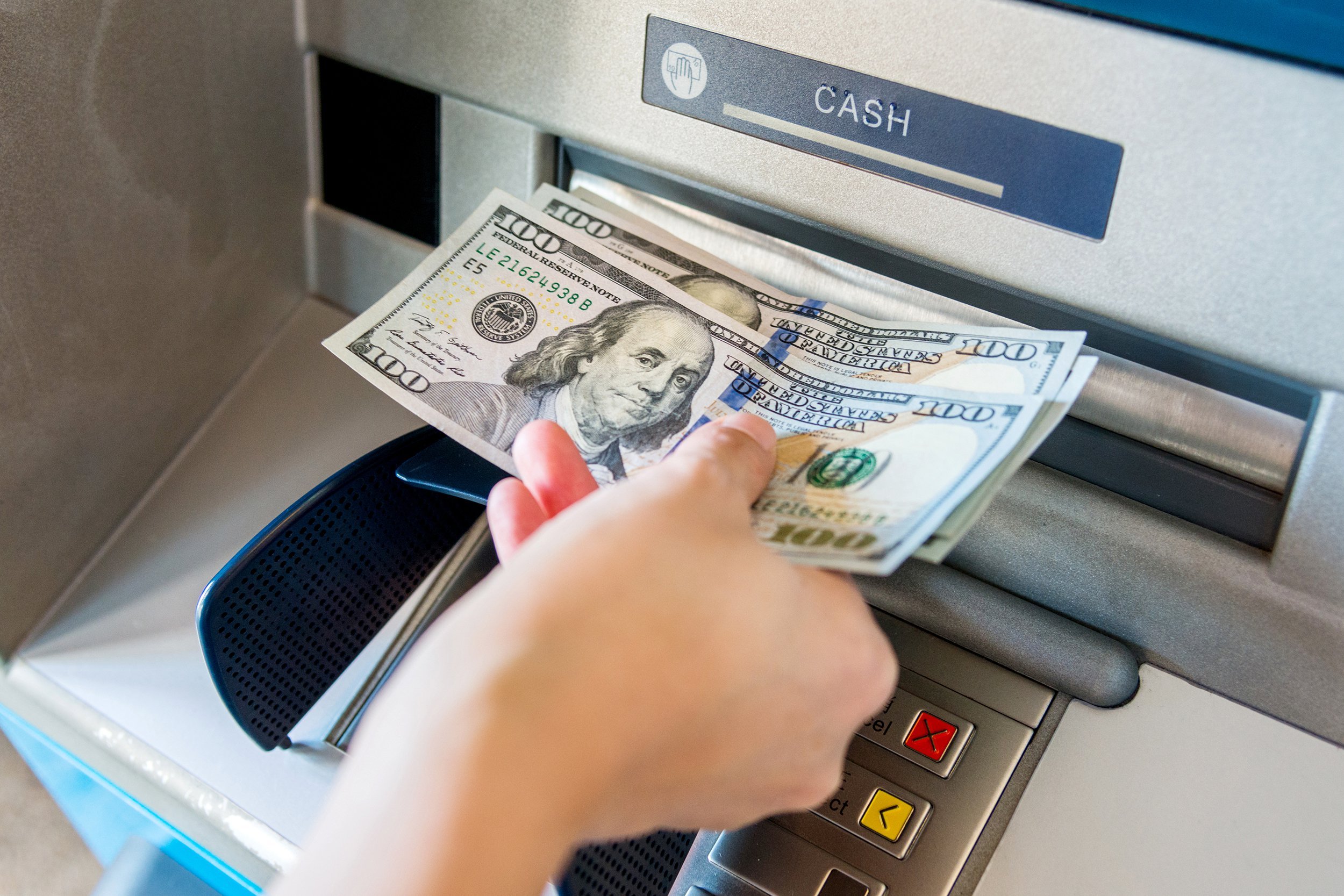 Hand taking money out of an ATM