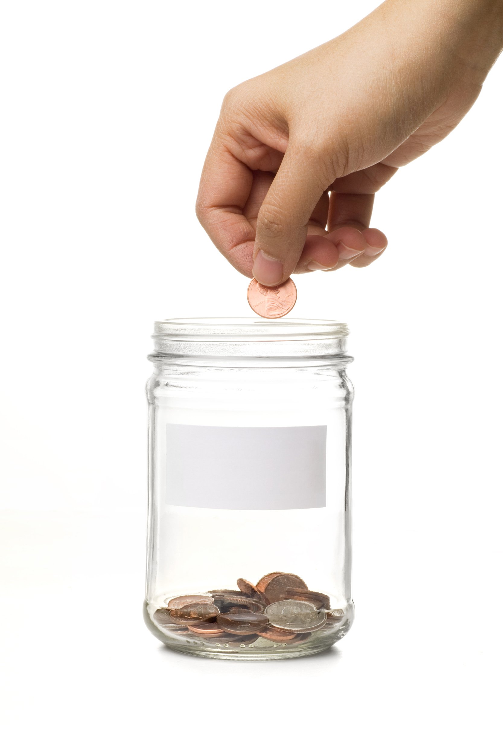 Hand putting a penny in a glass jar
