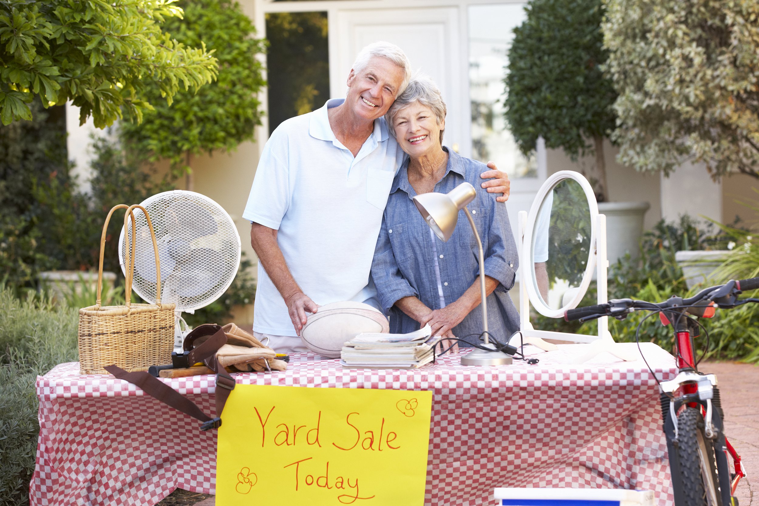Senior couple having a yard sale to get rid of old items