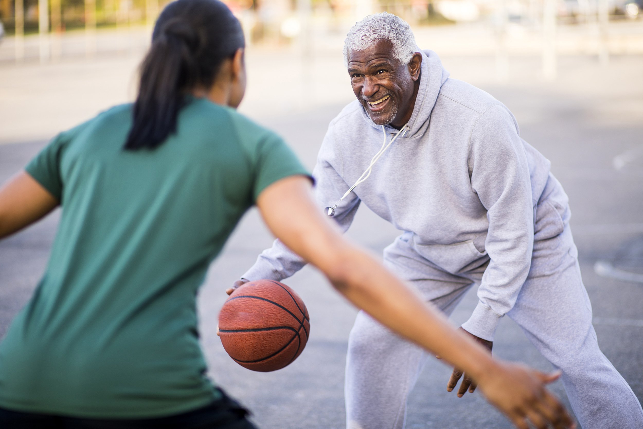 Senior man playing basketball with his daughter or granddaughter