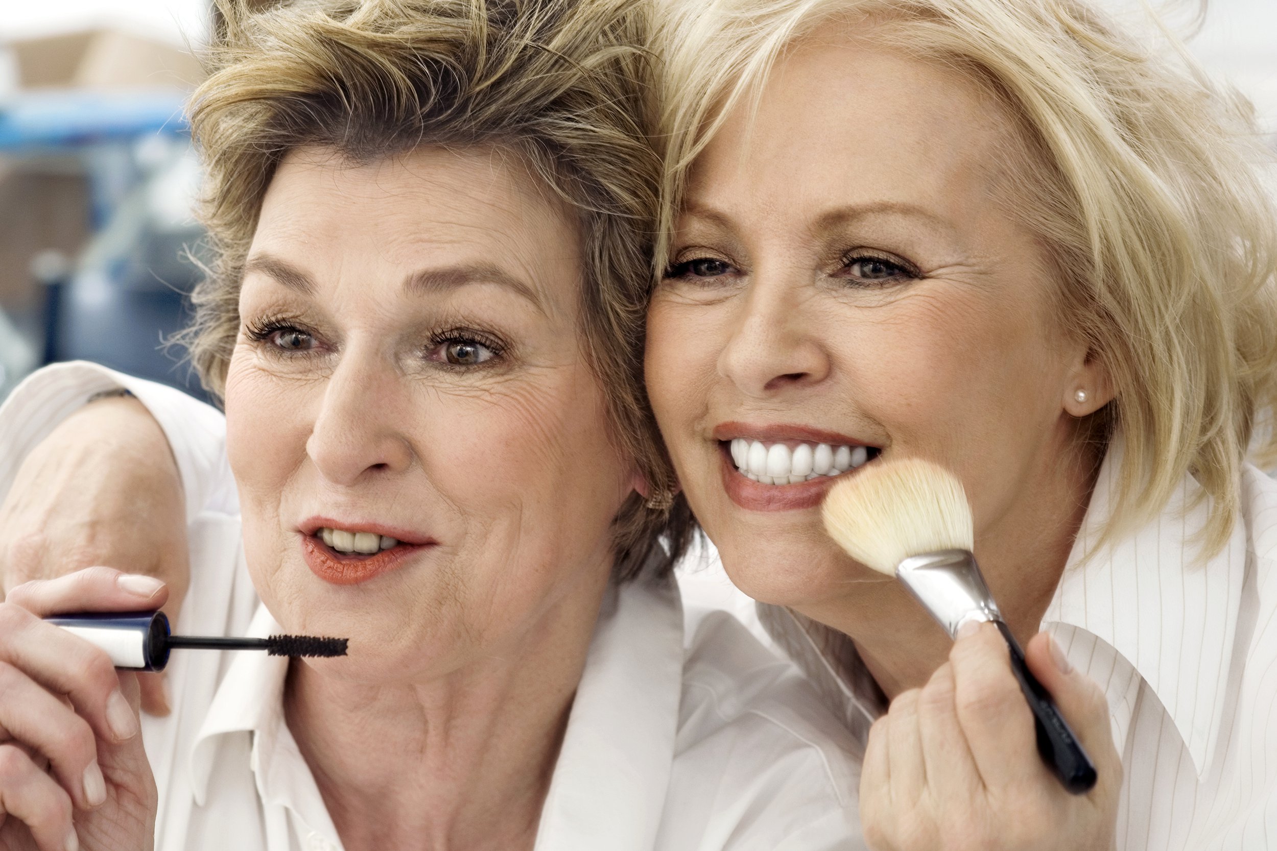 Two senior woman applying makeup