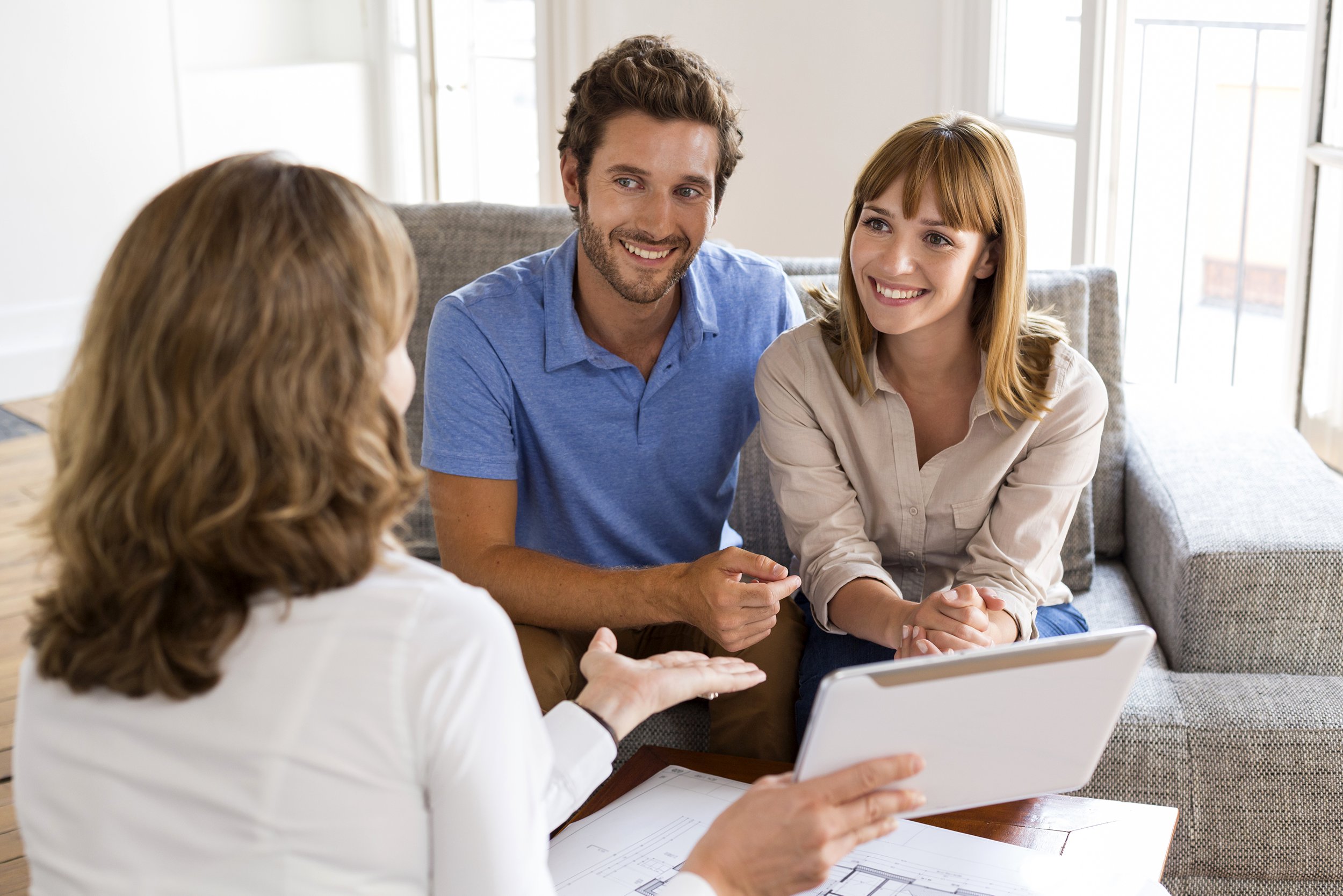 Couple speaking with real estate agent at home