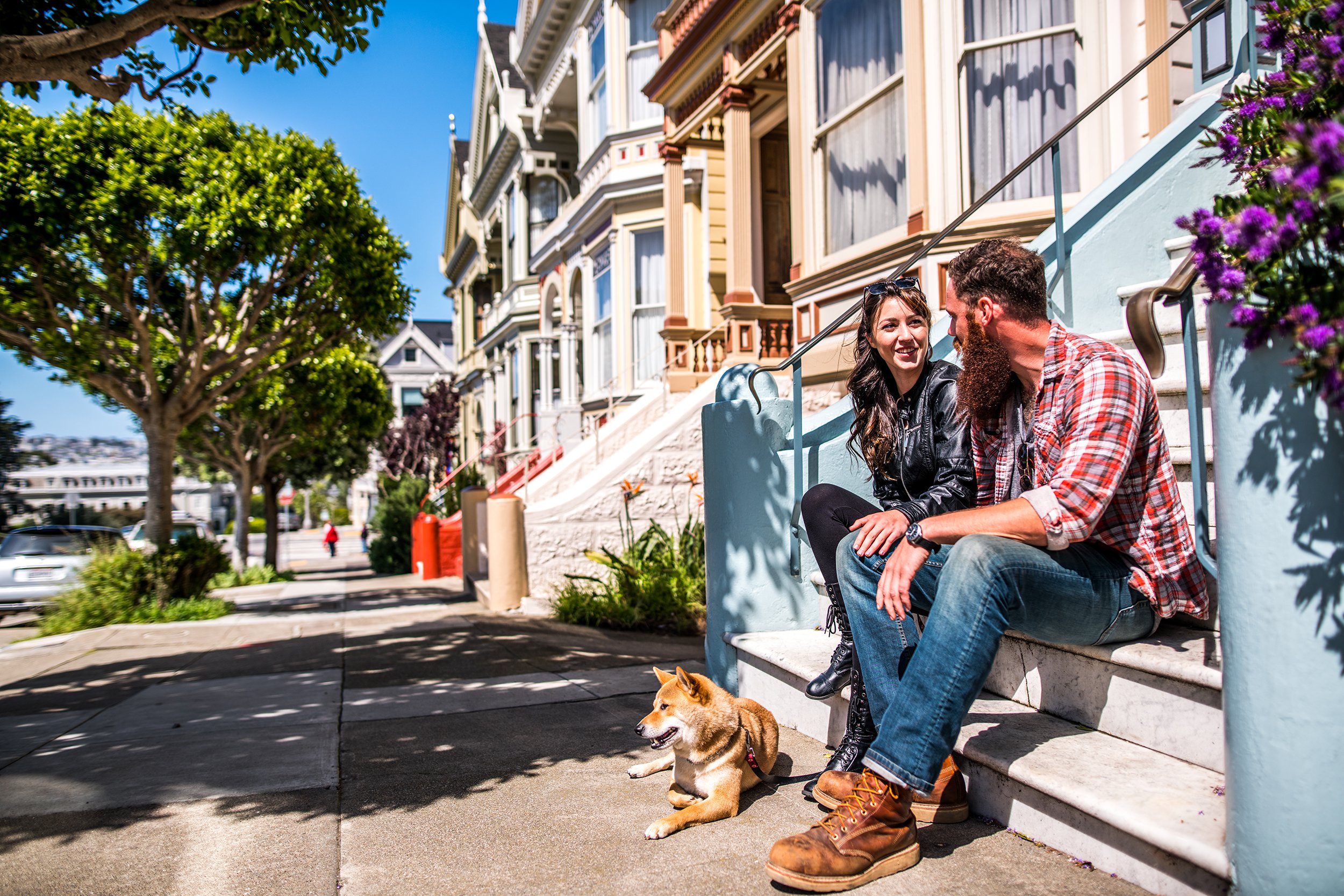 couple with a dog sitting on steps of home