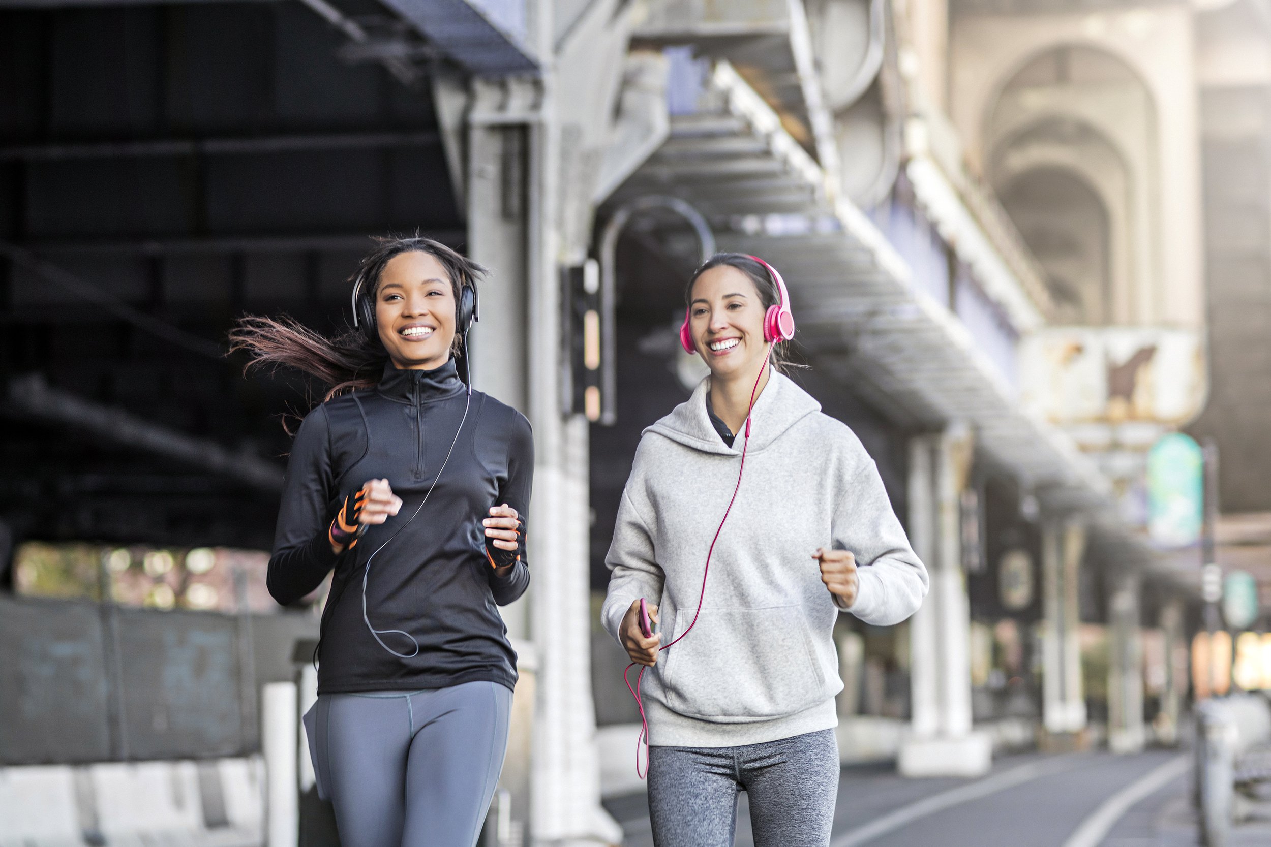 female friends running on the city street