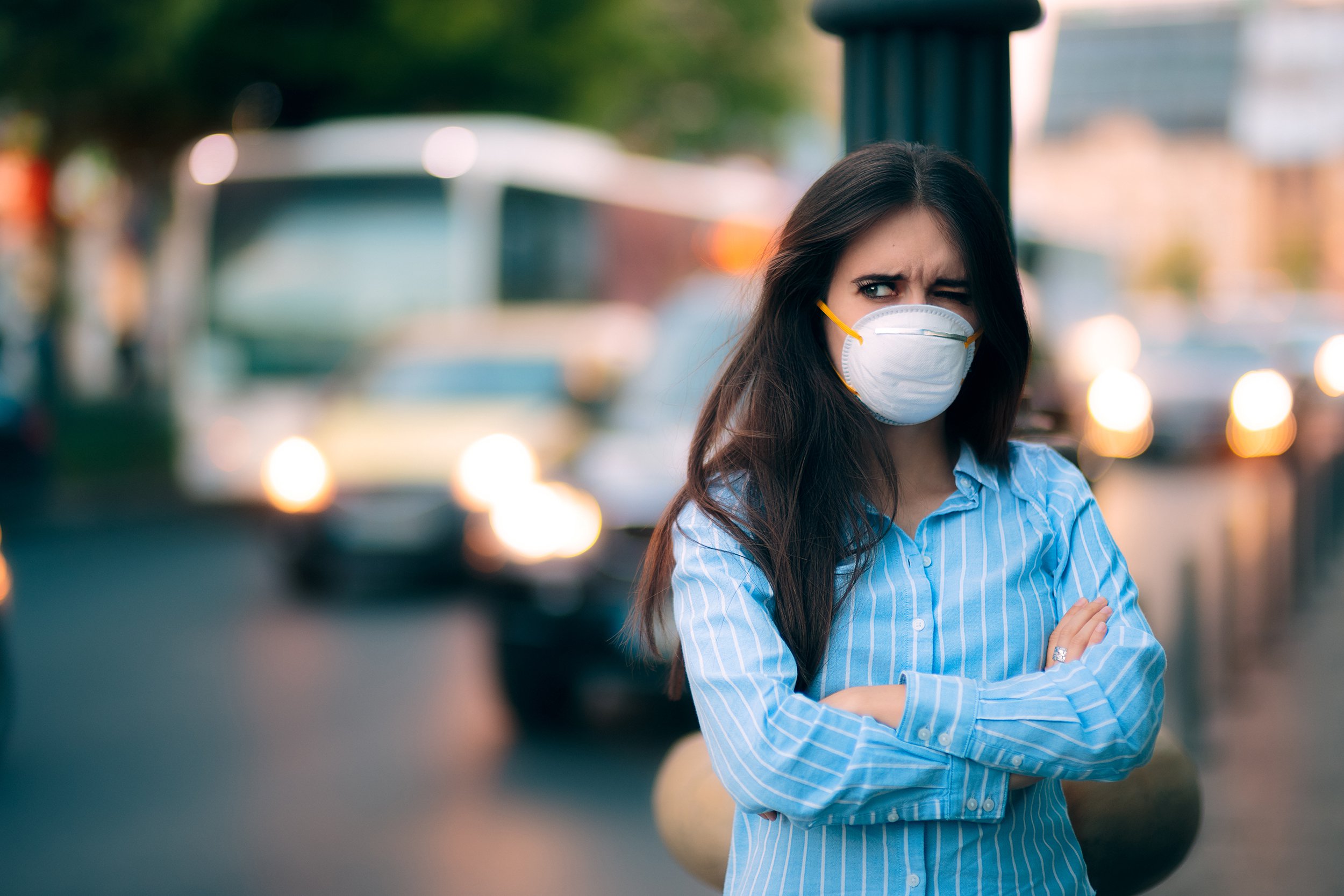 woman with respiratory mask out in polluted city