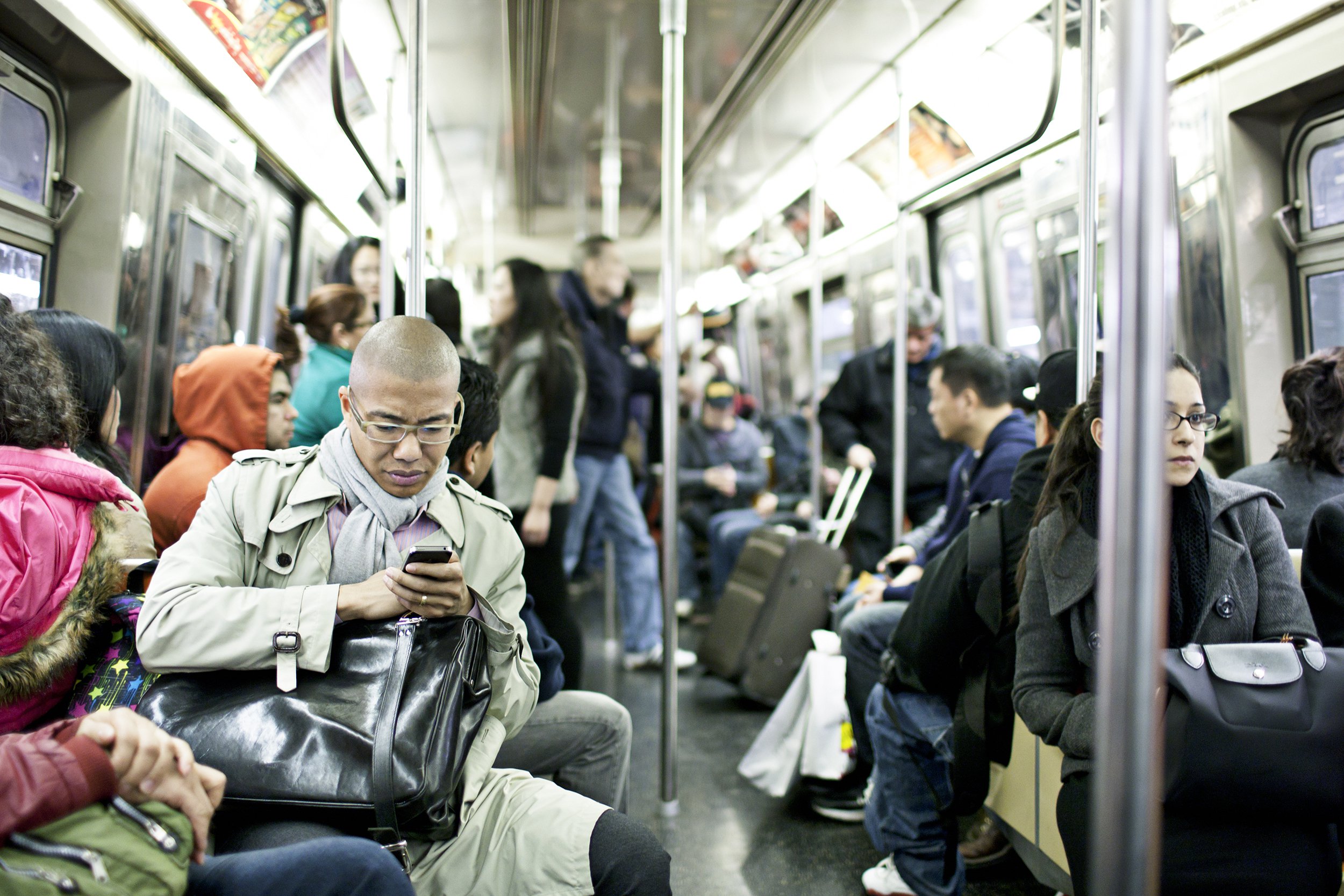 people traveling in a busy subway train in New York City
