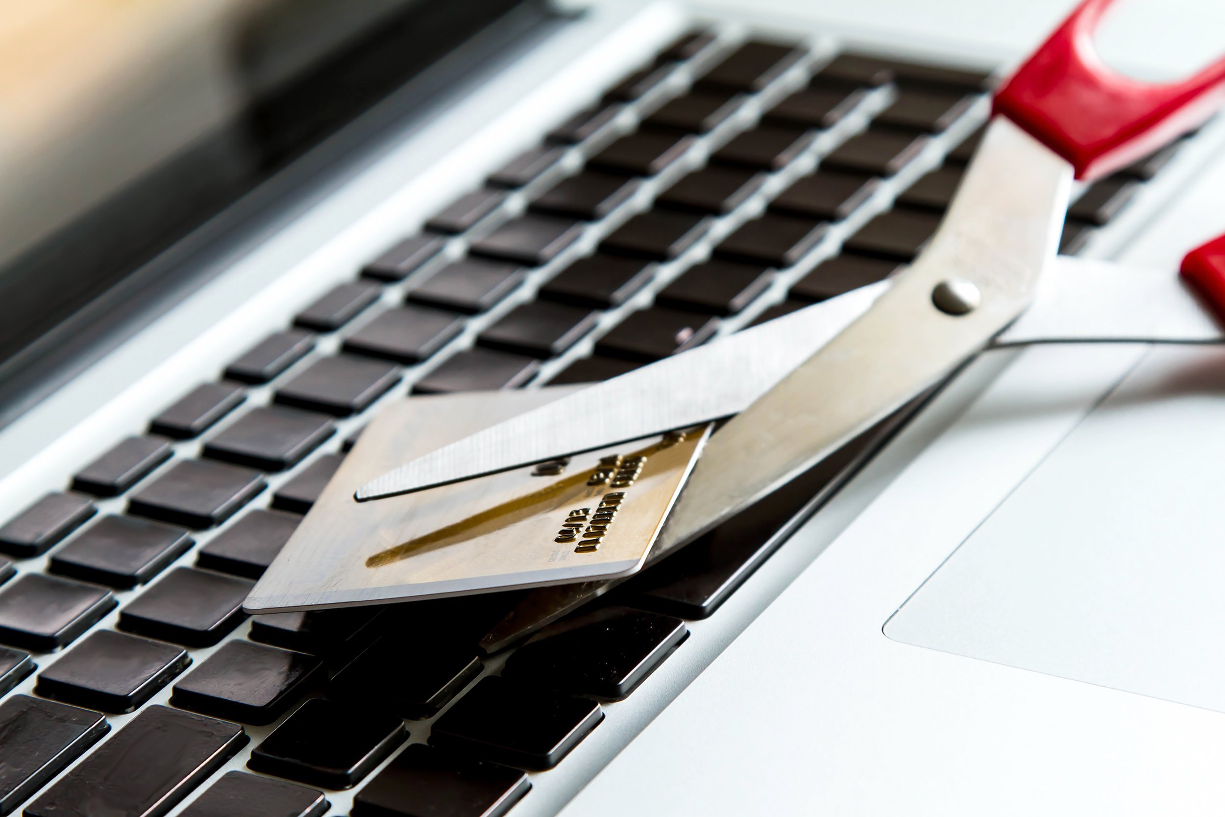 scissors cutting credit card on laptop