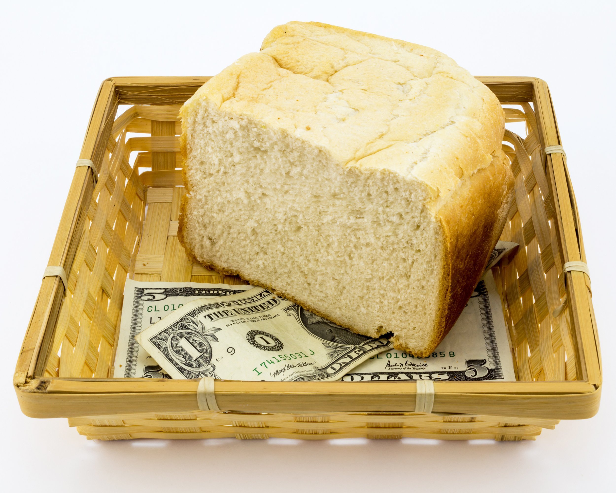 5 and 1 dollar notes with half a loaf of white bread in basket
