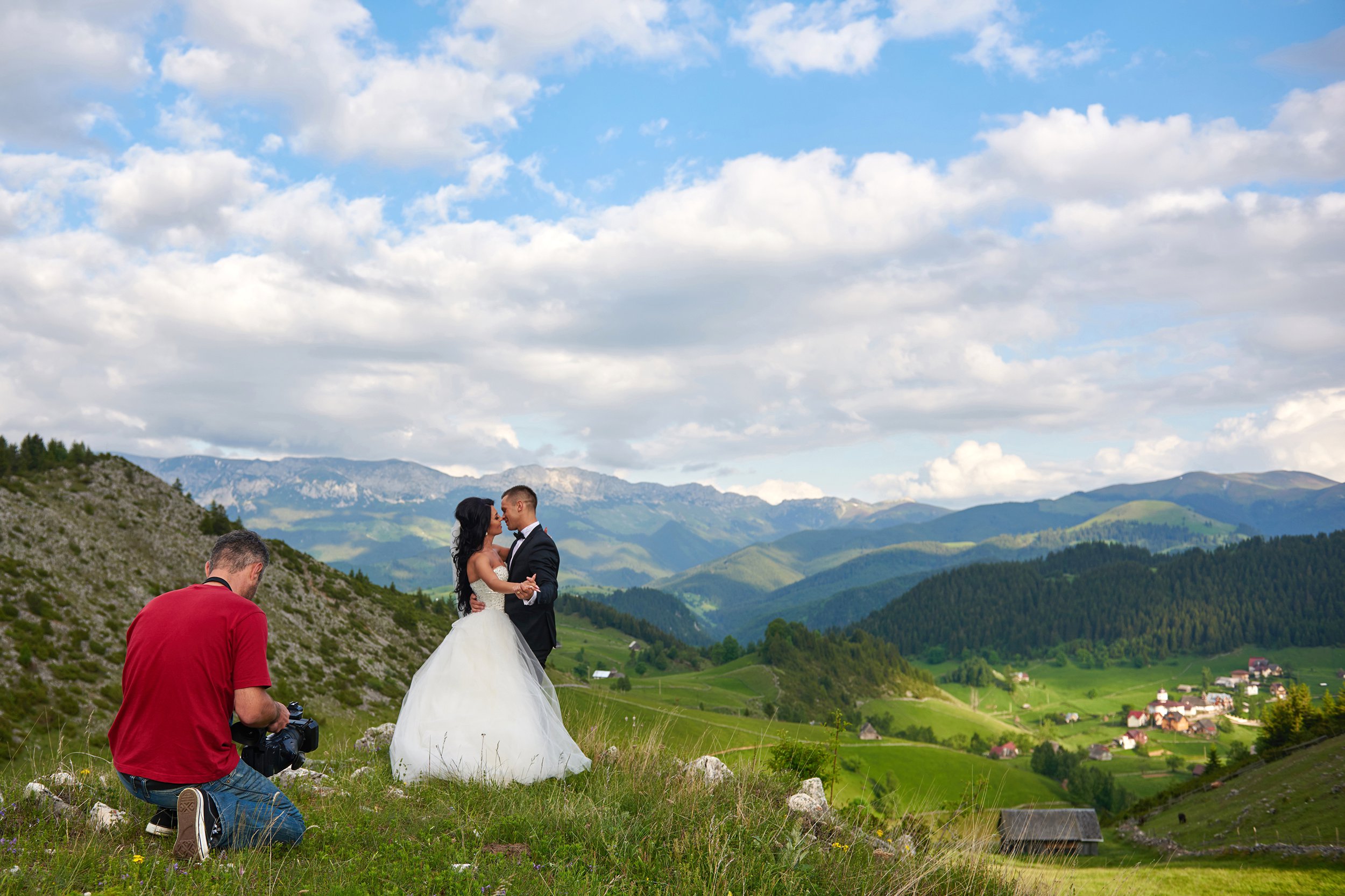 Married couple posing for a photographer with a beautiful mountain scenery