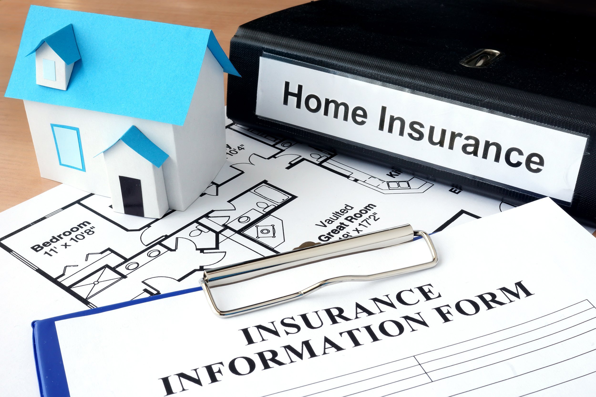 model of house and folder with home insurance