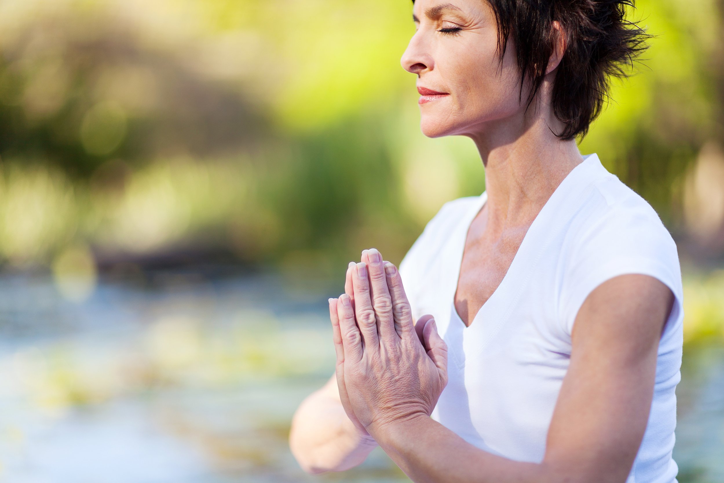 Older woman meditating outside