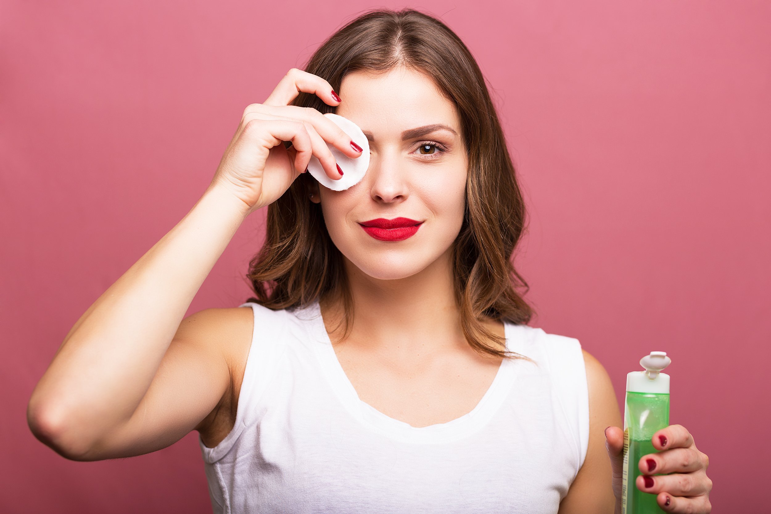 woman cleaning her face with a cotton pad