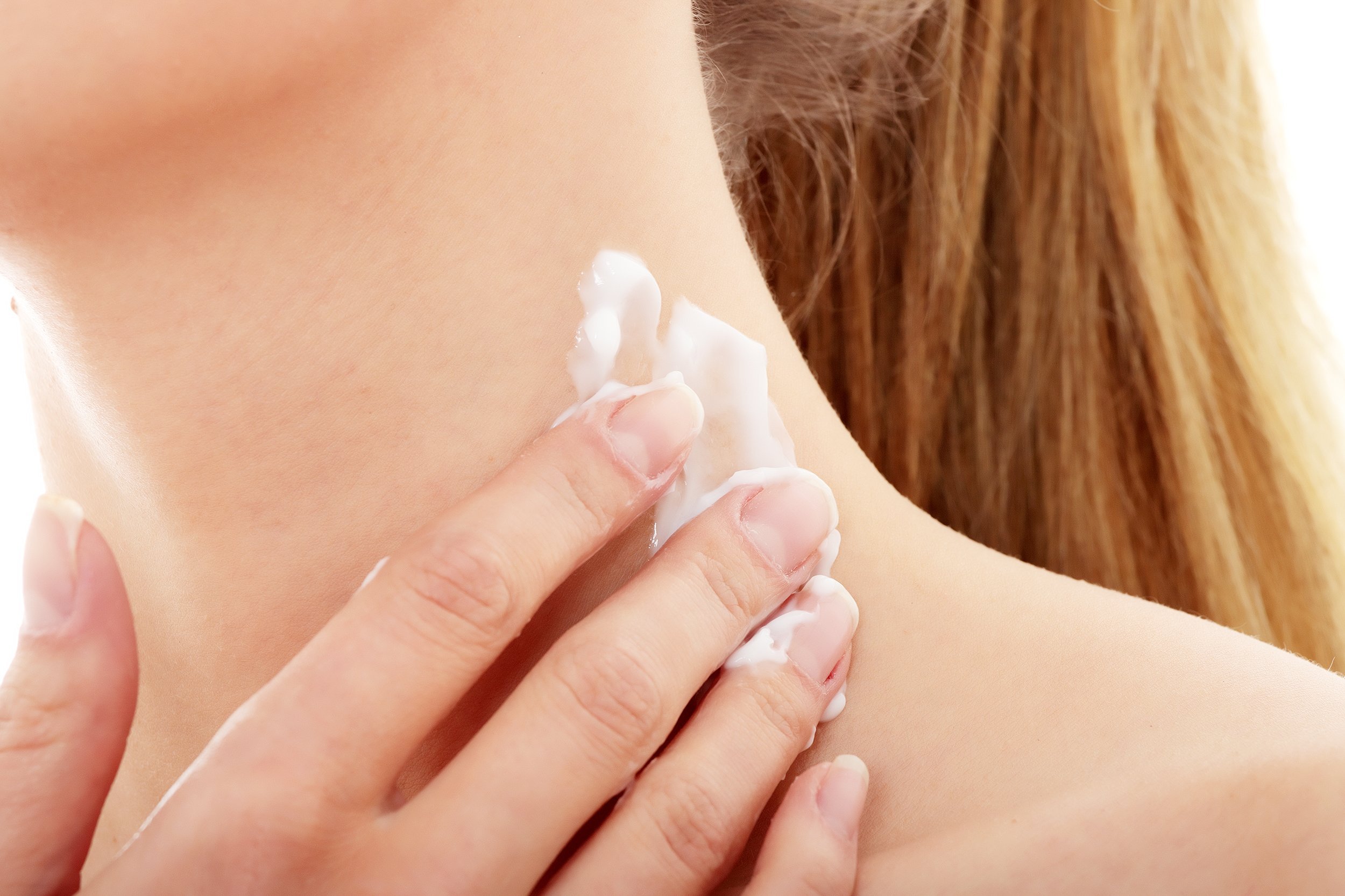 woman applying cream to neck area