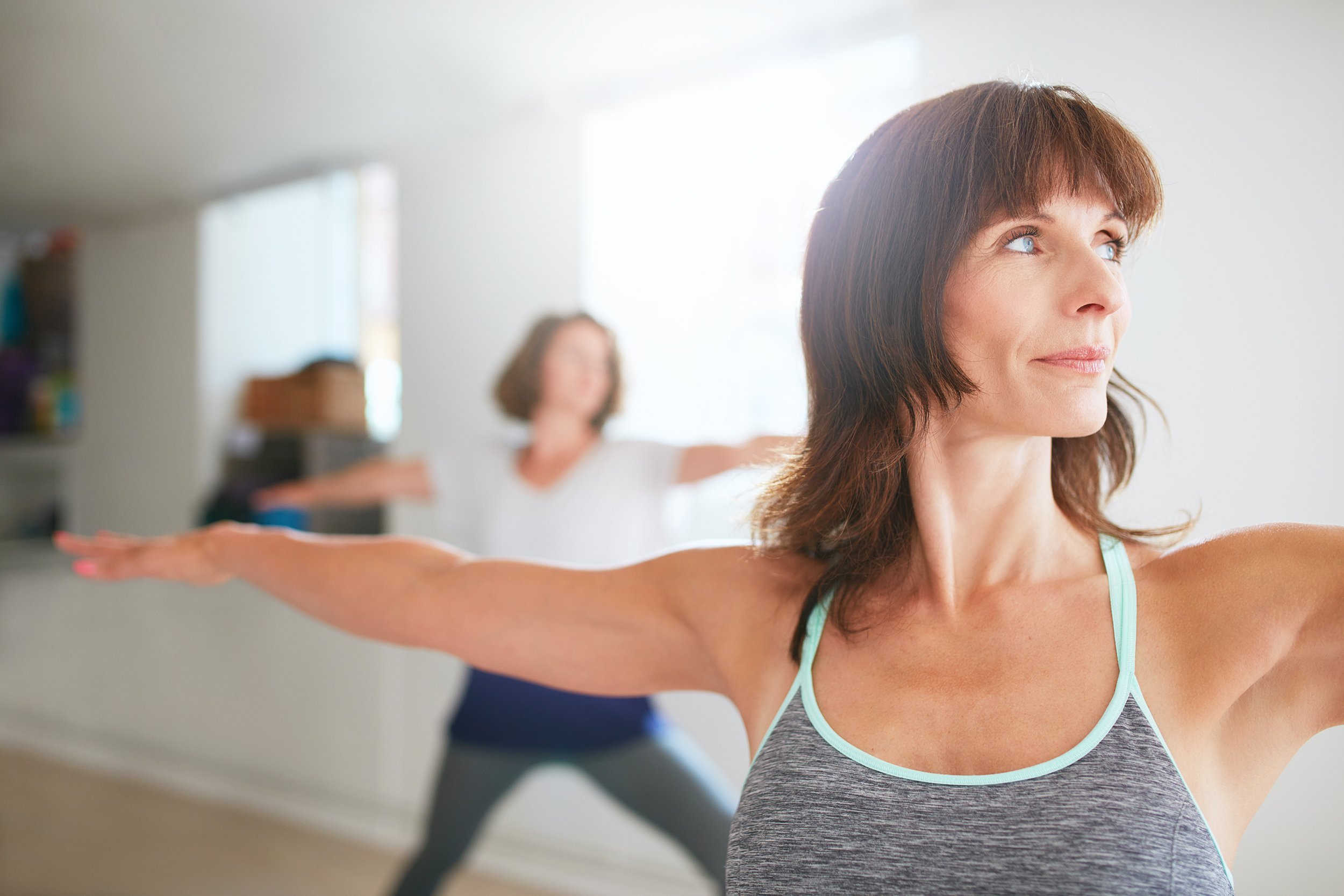woman doing the warrior pose during yoga class