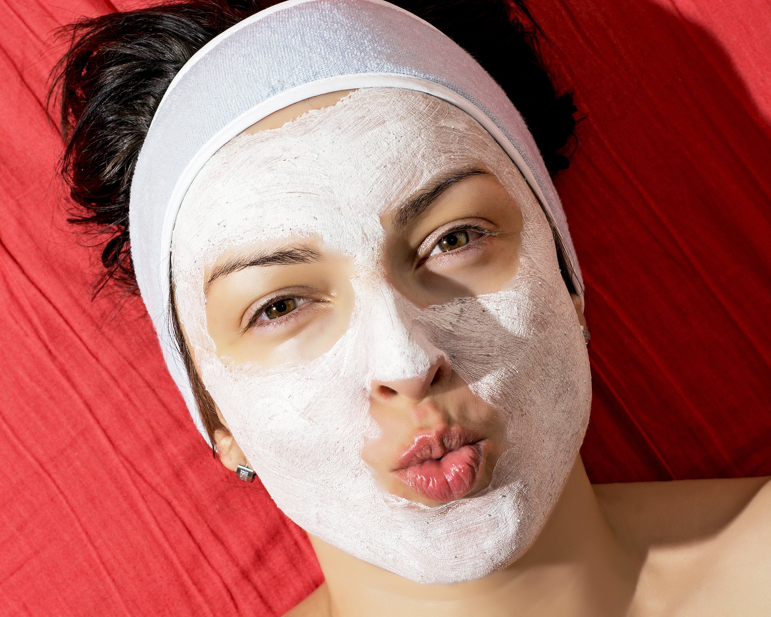 woman with white smoothing face mask sending a kiss