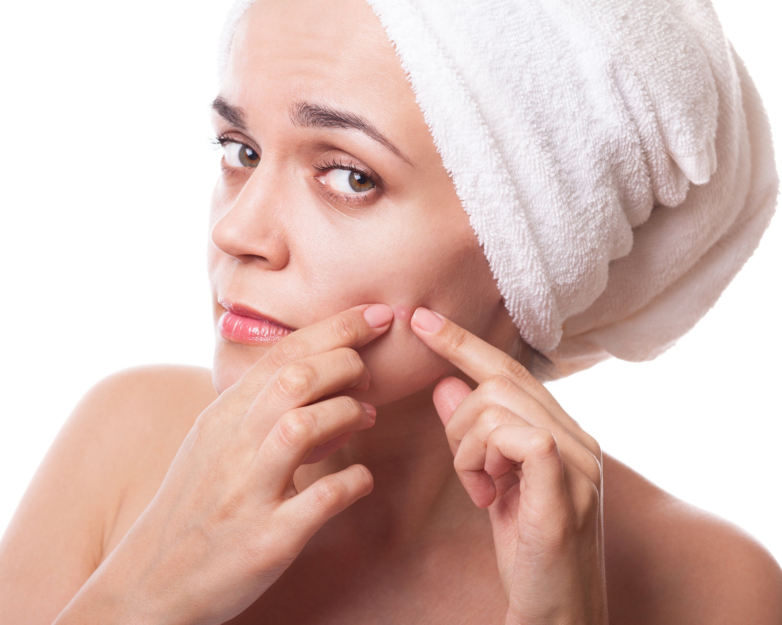 woman with a towel on her had squeezing pimple