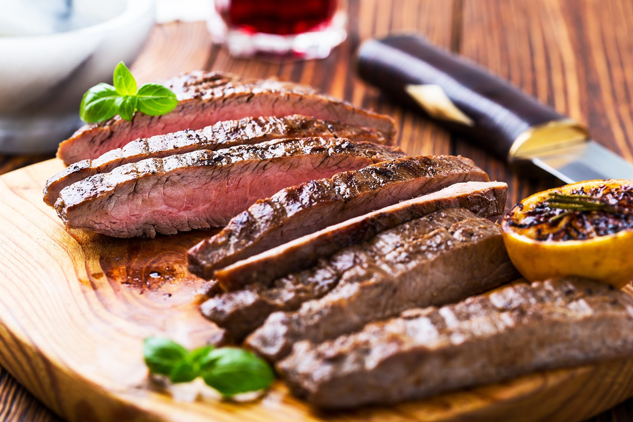 grilled marinated beef flank steak on wooden board