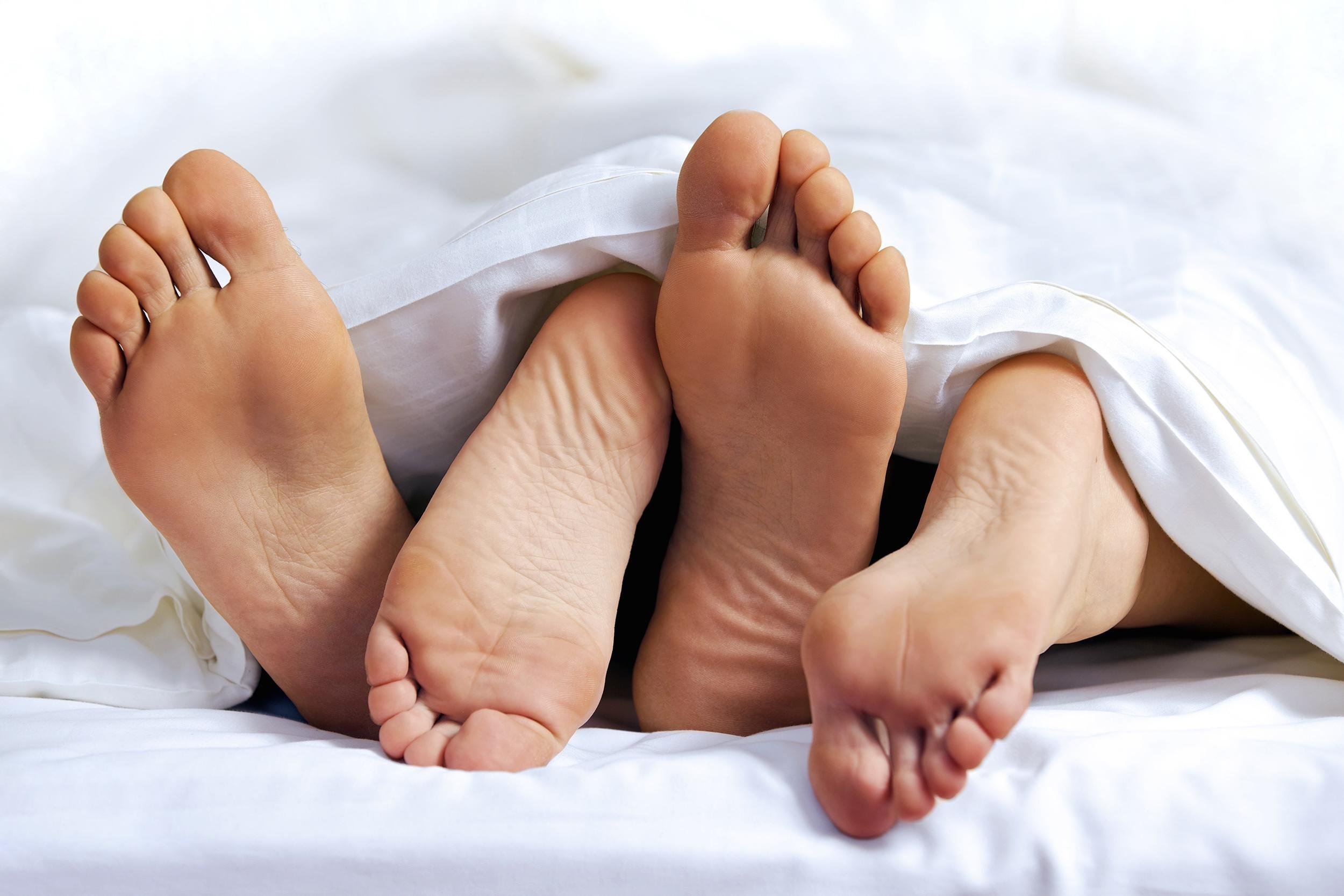 close-up of the feet of a couple on the bed
