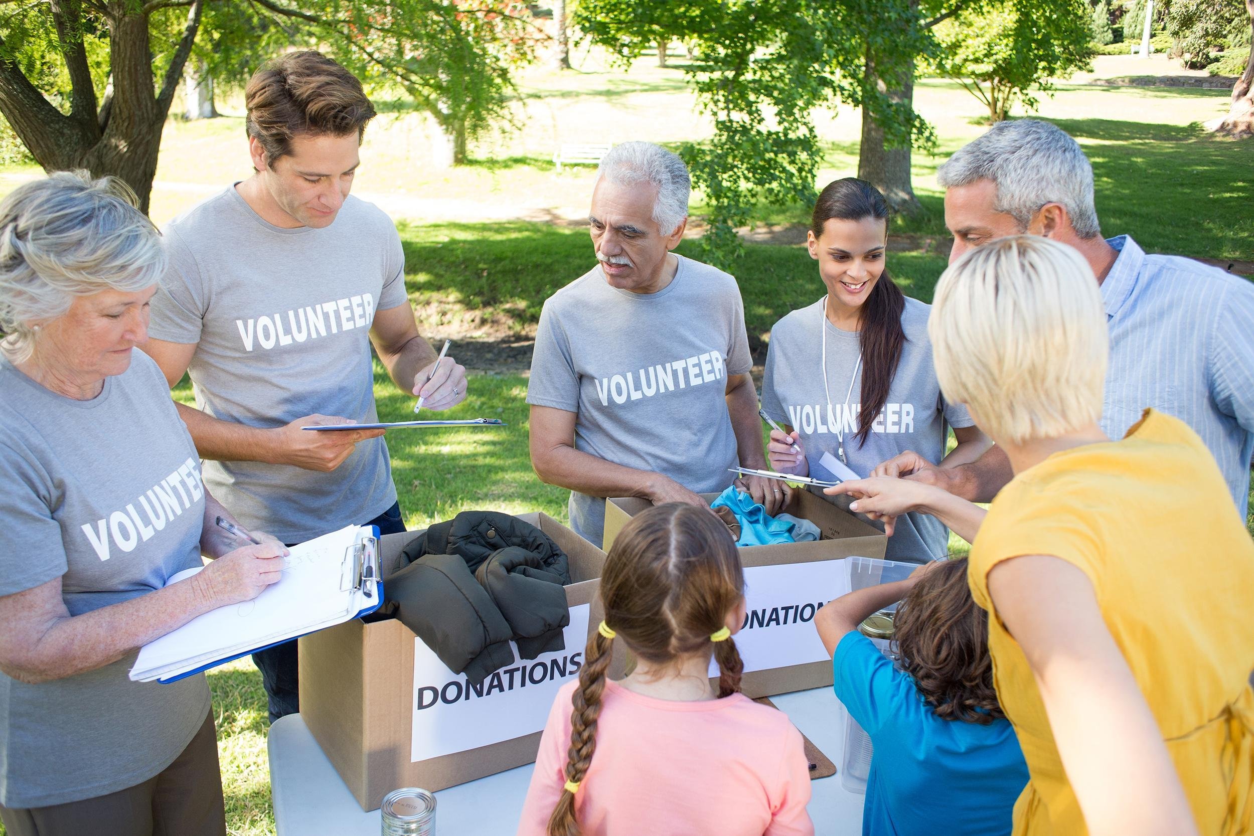 happy volunteer family separating donations stuffs on a sunny day