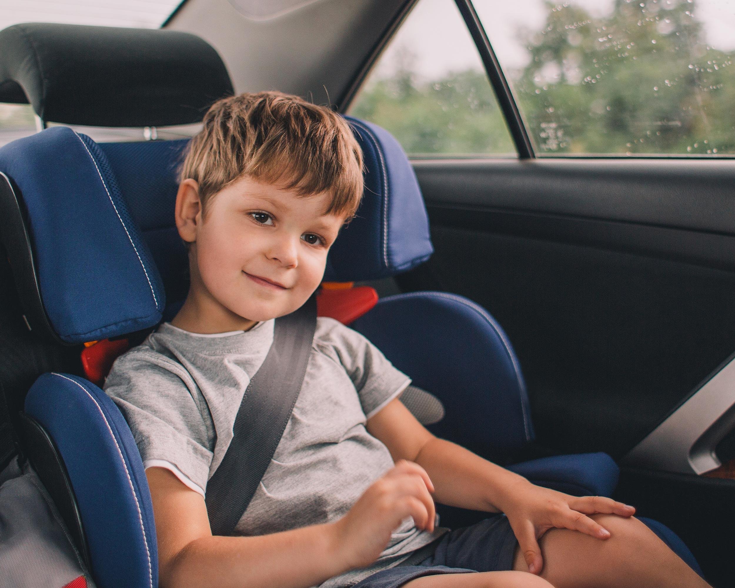 little boy sitting in safety car seat