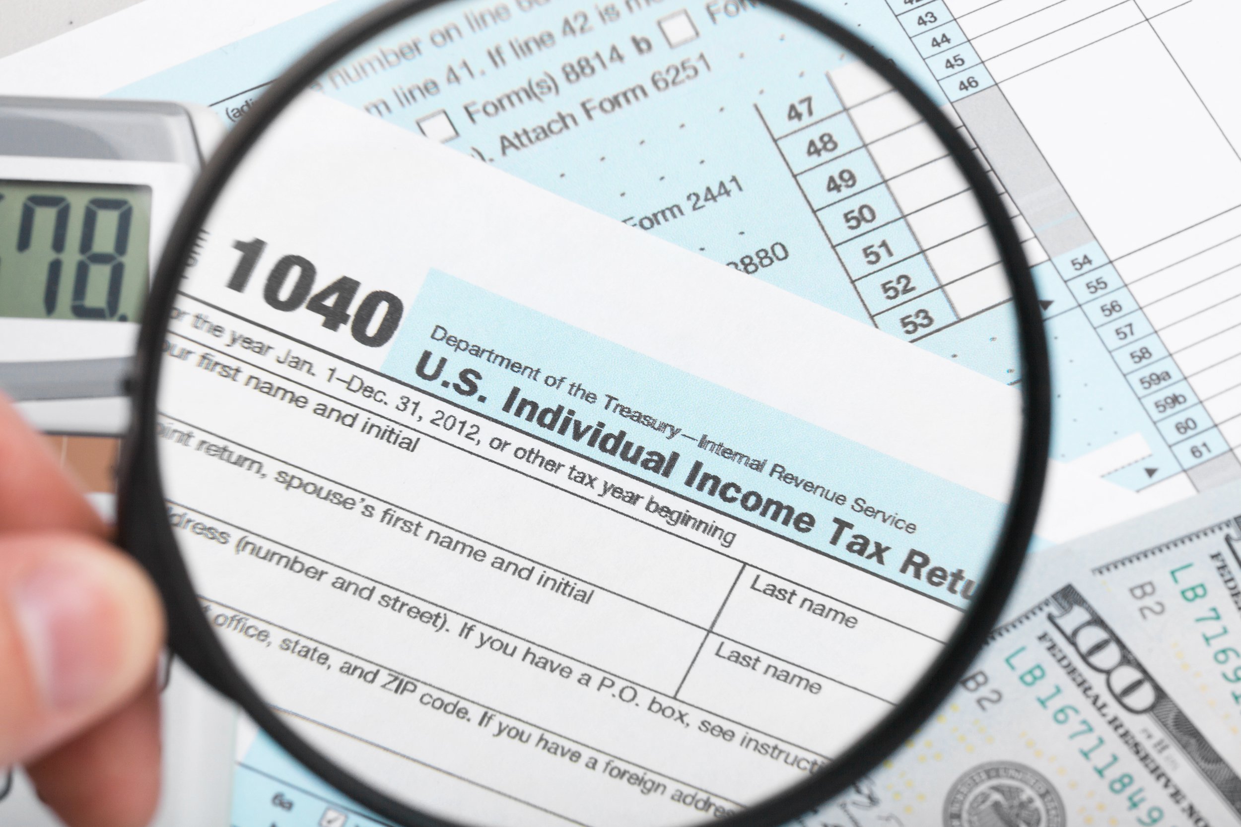 Tax Form 1040 with magnifying glass