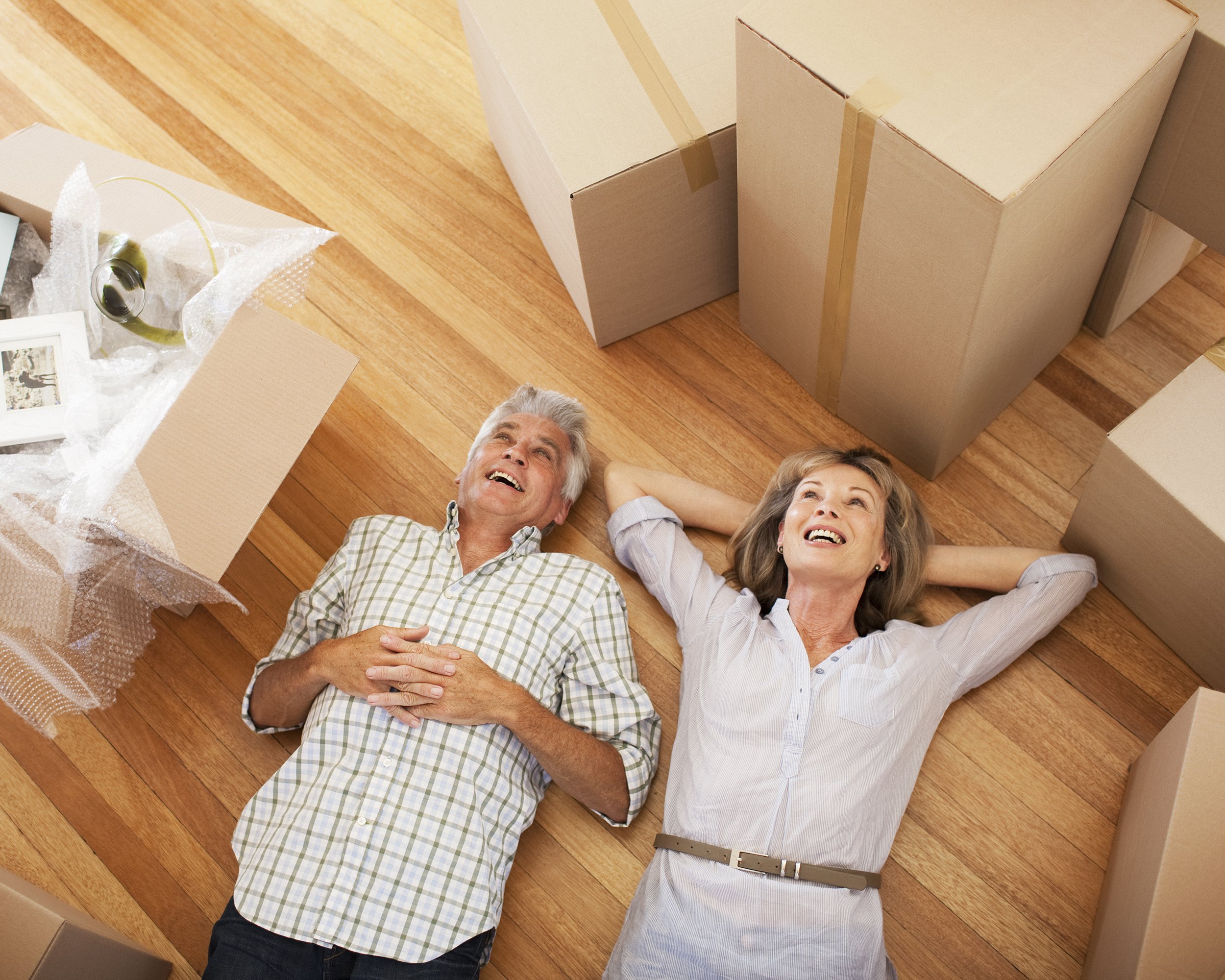 happy couple laying on floor of new house