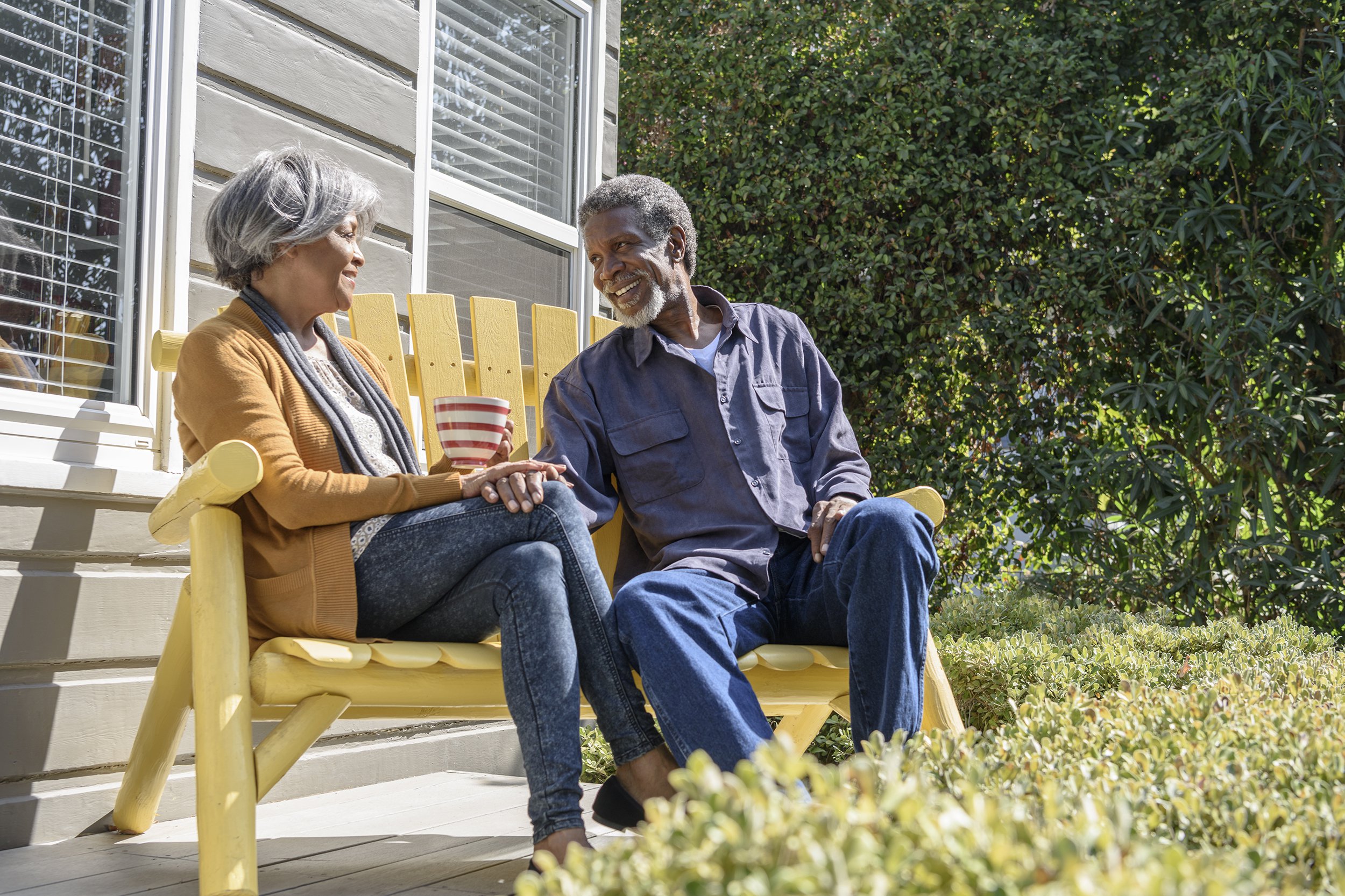 senior African American couple sitting on bench talking
