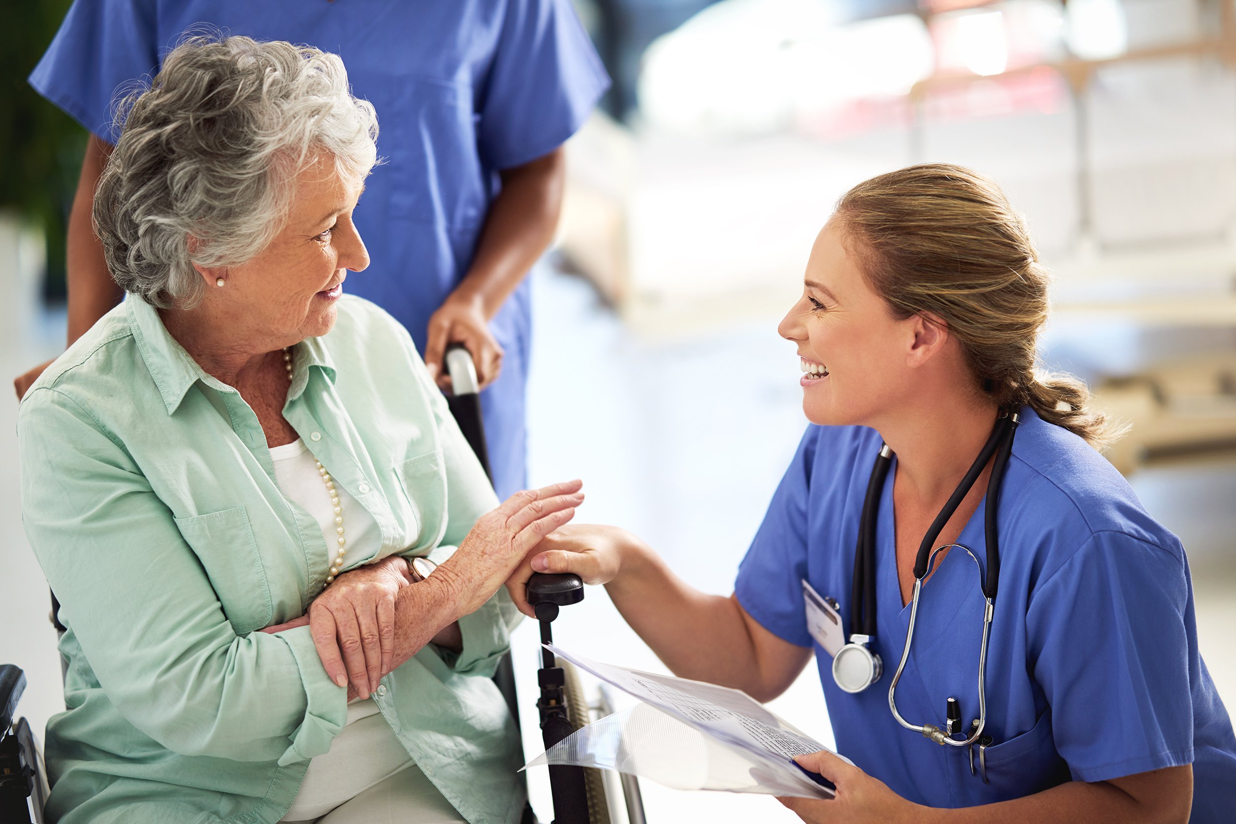 senior woman in wheelchair, talking to doctor