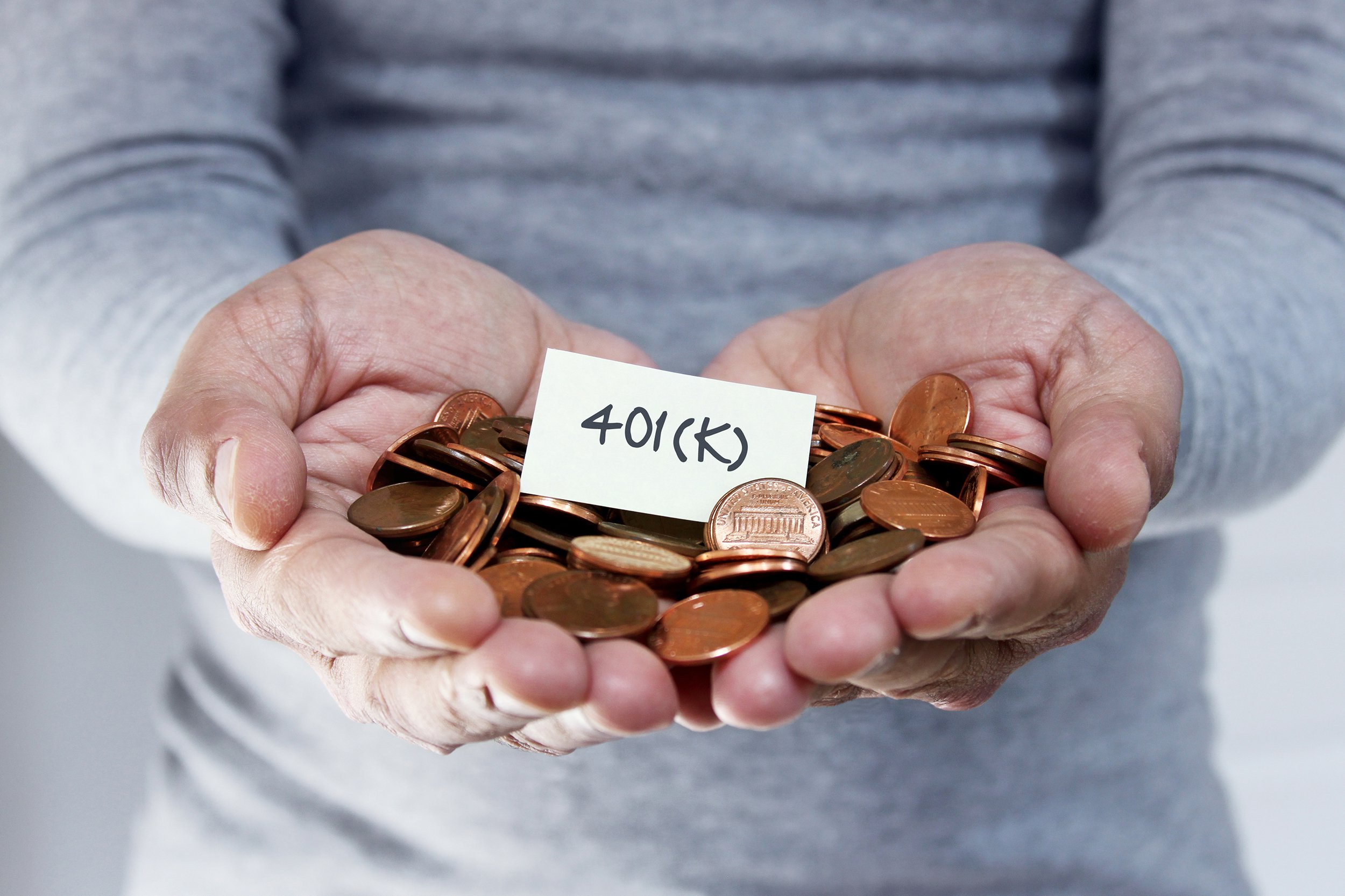senior hands holding pennies of 401(k)