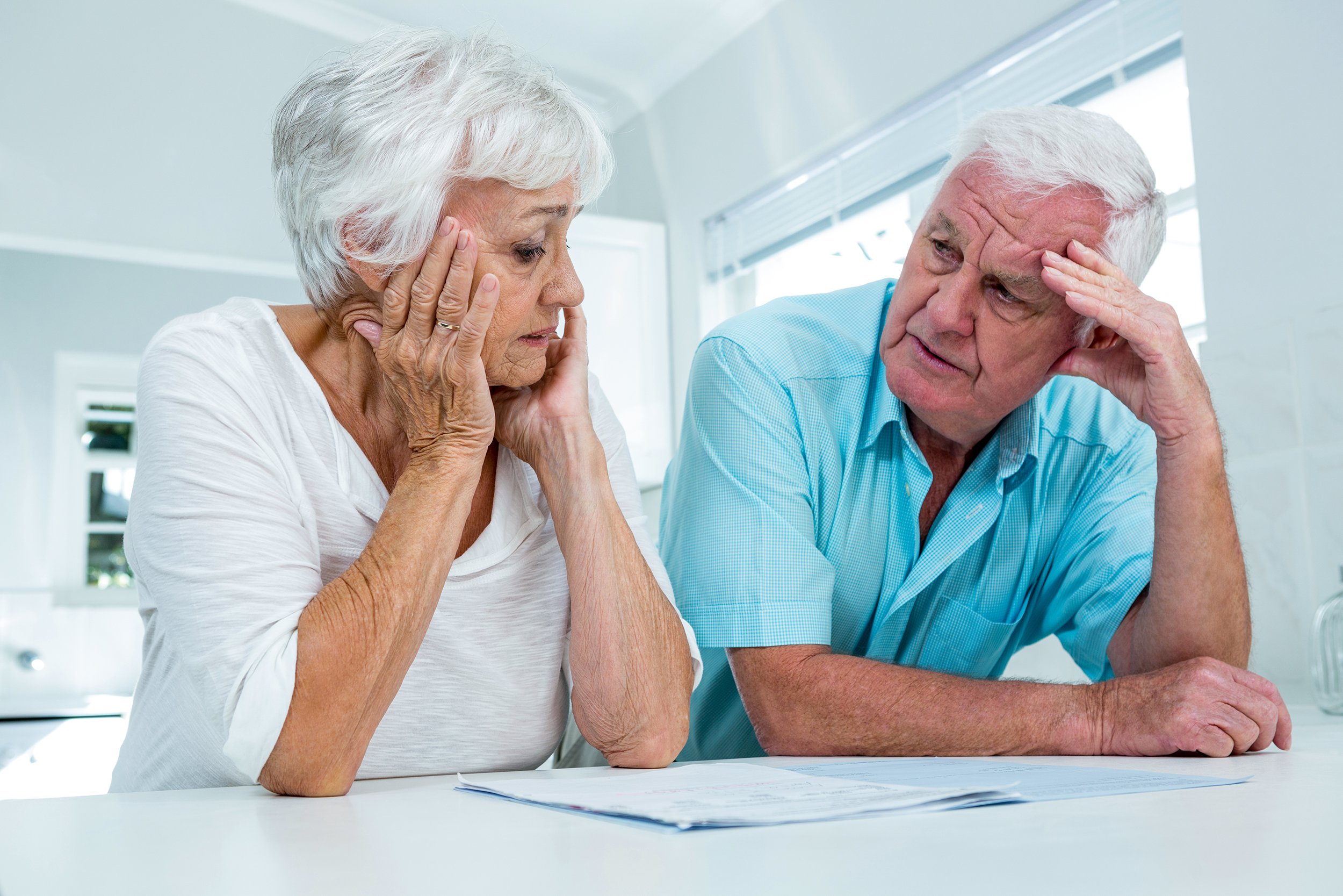 tensed senior couple talking to each other at home