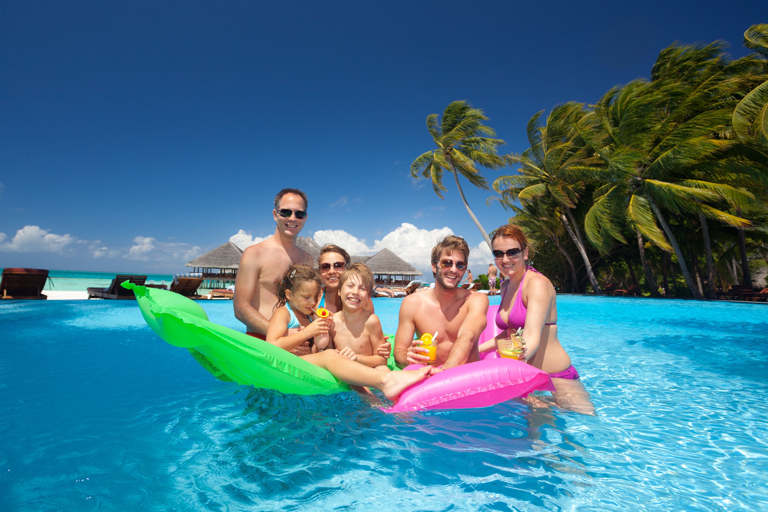 Happy family in a pool at a tropical resort